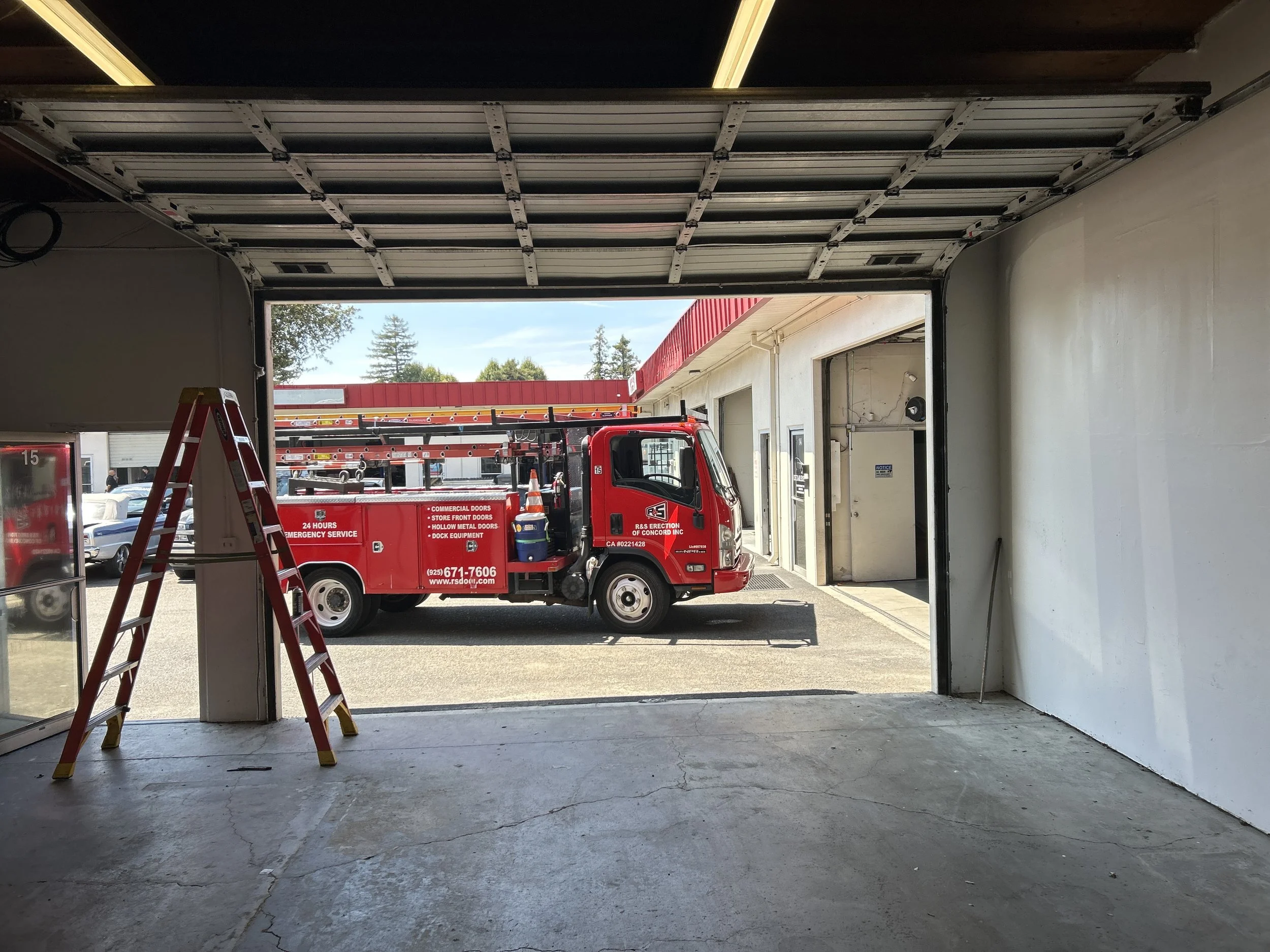R&S Red Truck at service call to repair sectional door at business.