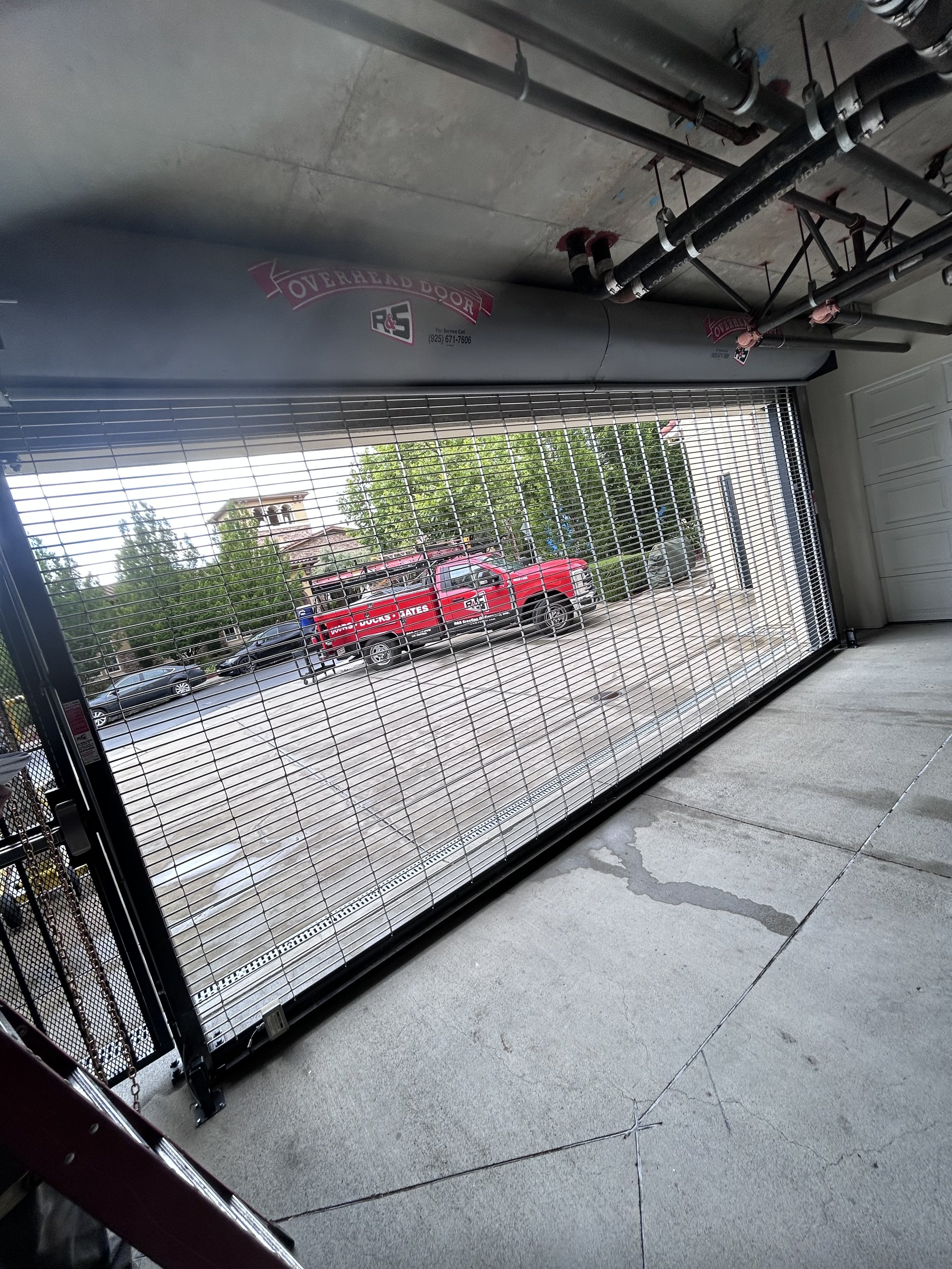 R&S Concord red truck behind a parking garage grille