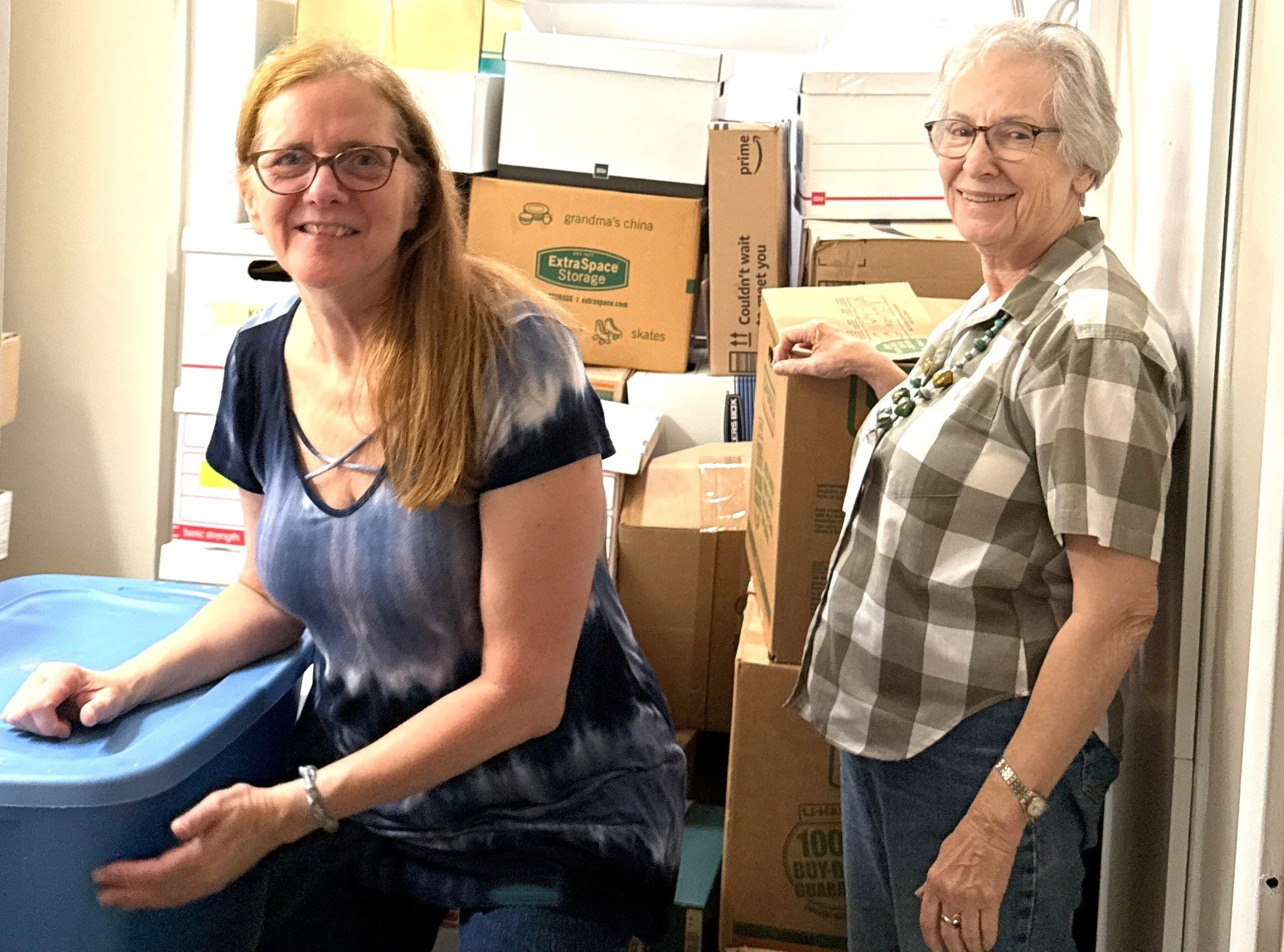 Two women working together while sorting belongings for downsizing