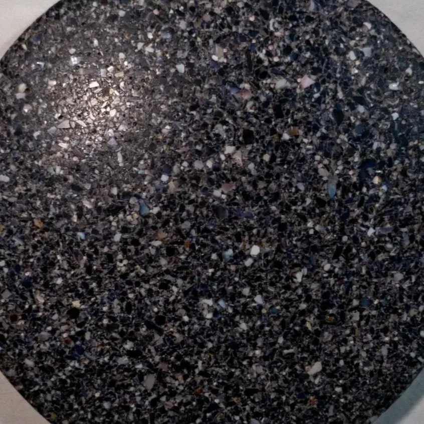 Close-up of a Shellf Life hard shell mussel black, blue, purple speckled countertop surface.