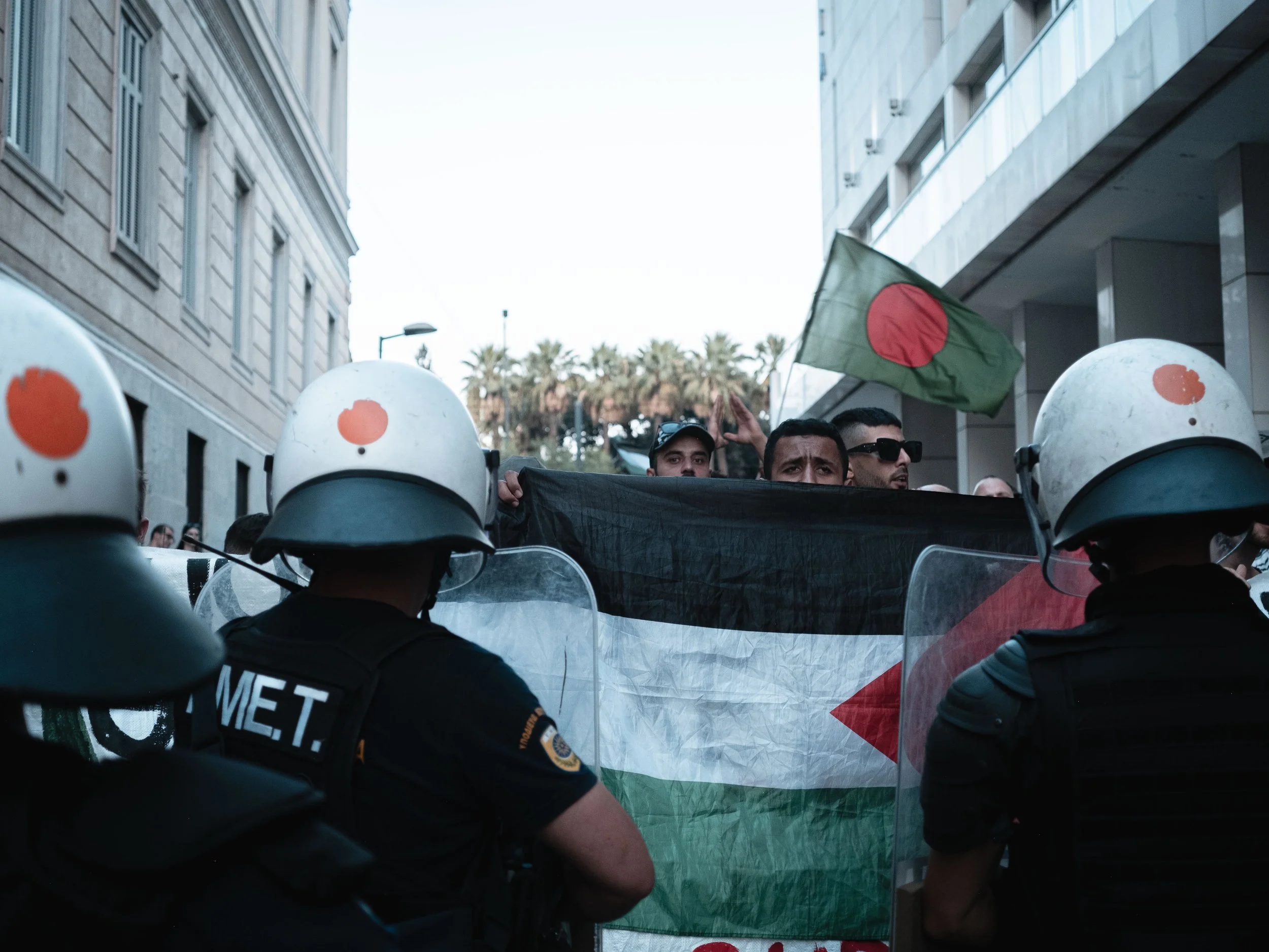 Protesters holds Palestine flag infront of Riot Police during a solidarity gathering with Palestine in Athens,Greece.