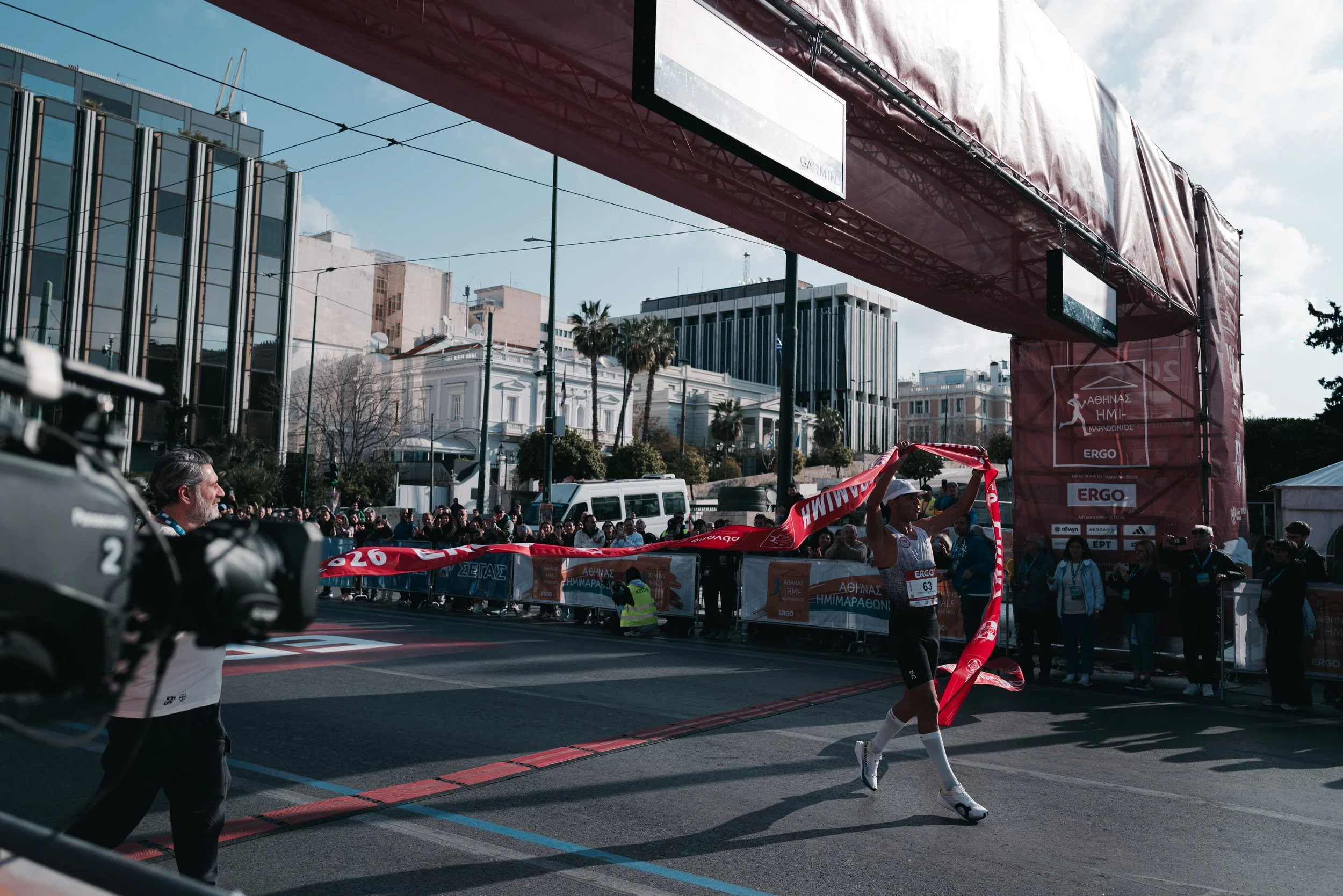 The winner of the men's race crosses the finish line holding the tape and setting a new course record during the Athens Half Marathon in Athens, Greece on March 8, 2026. The race gathers professional and amateur runners competing in the 21.1 kilomete