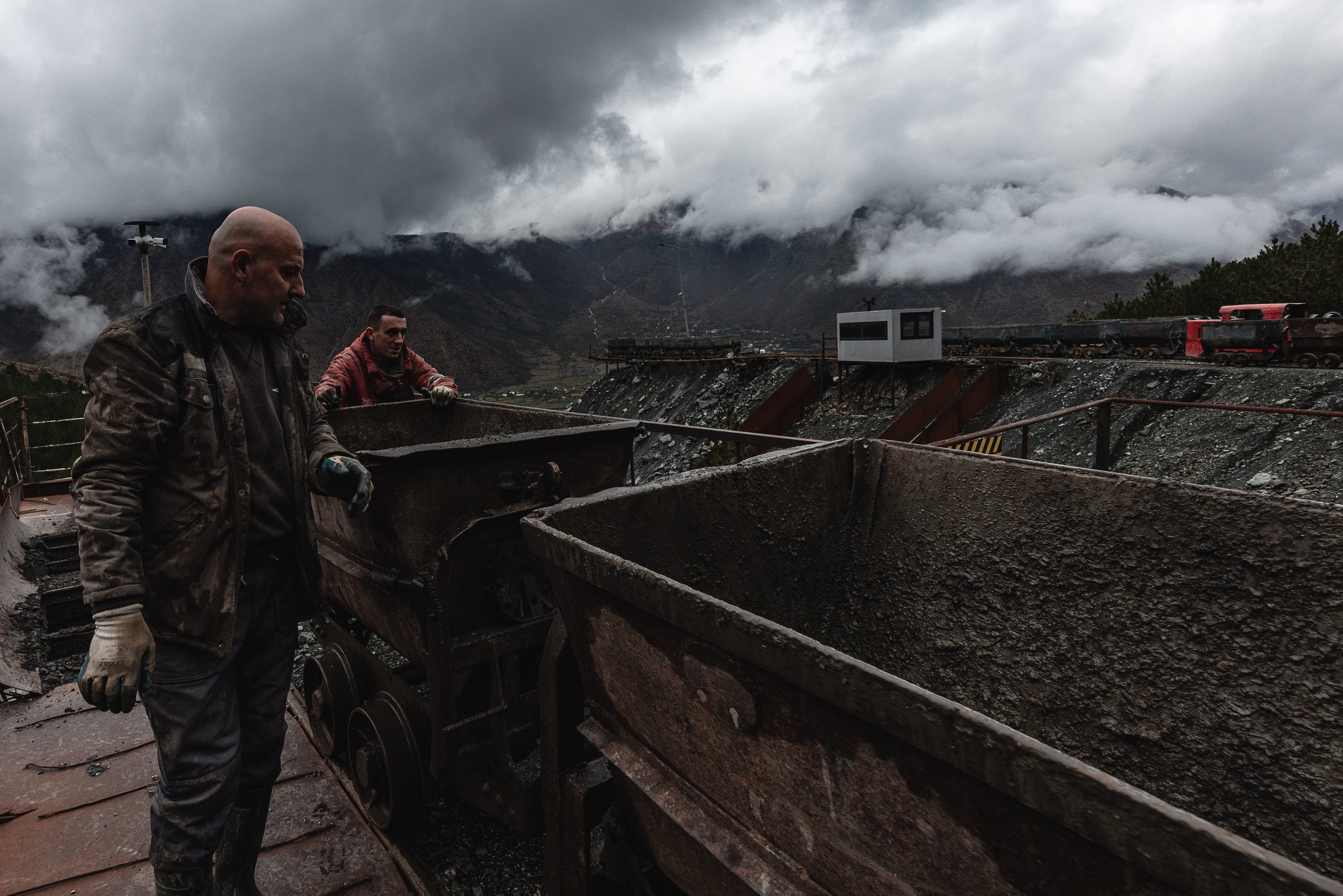 Workers push mine carts toward the mine to collect more extracted chromium in Bulqizë, Dibër County, Albania on November 11, 2025. The scene illustrates the ongoing manual labor required in one of Europe’s largest chromium mining regions.