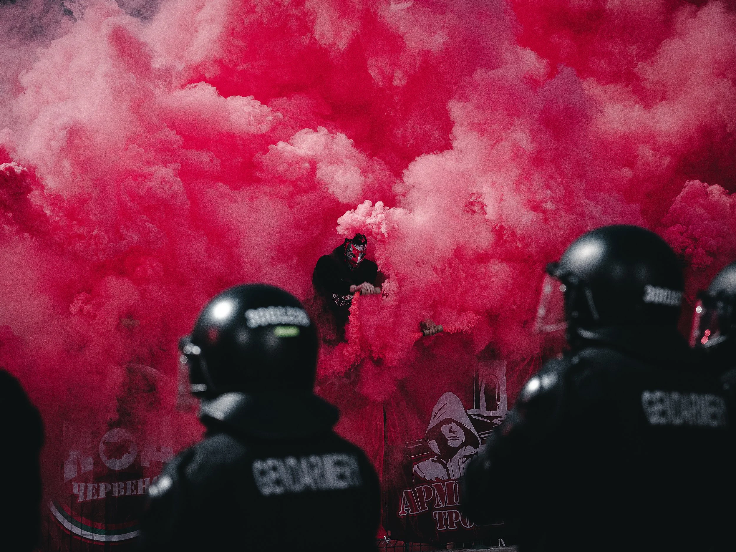 CSKA Sofia fans with smoke flares jump the fence onto the field during the Bulgarian Cup Final, while police officers stand firm on the field against the fans. Sofia, Bulgaria – May 22, 2025.