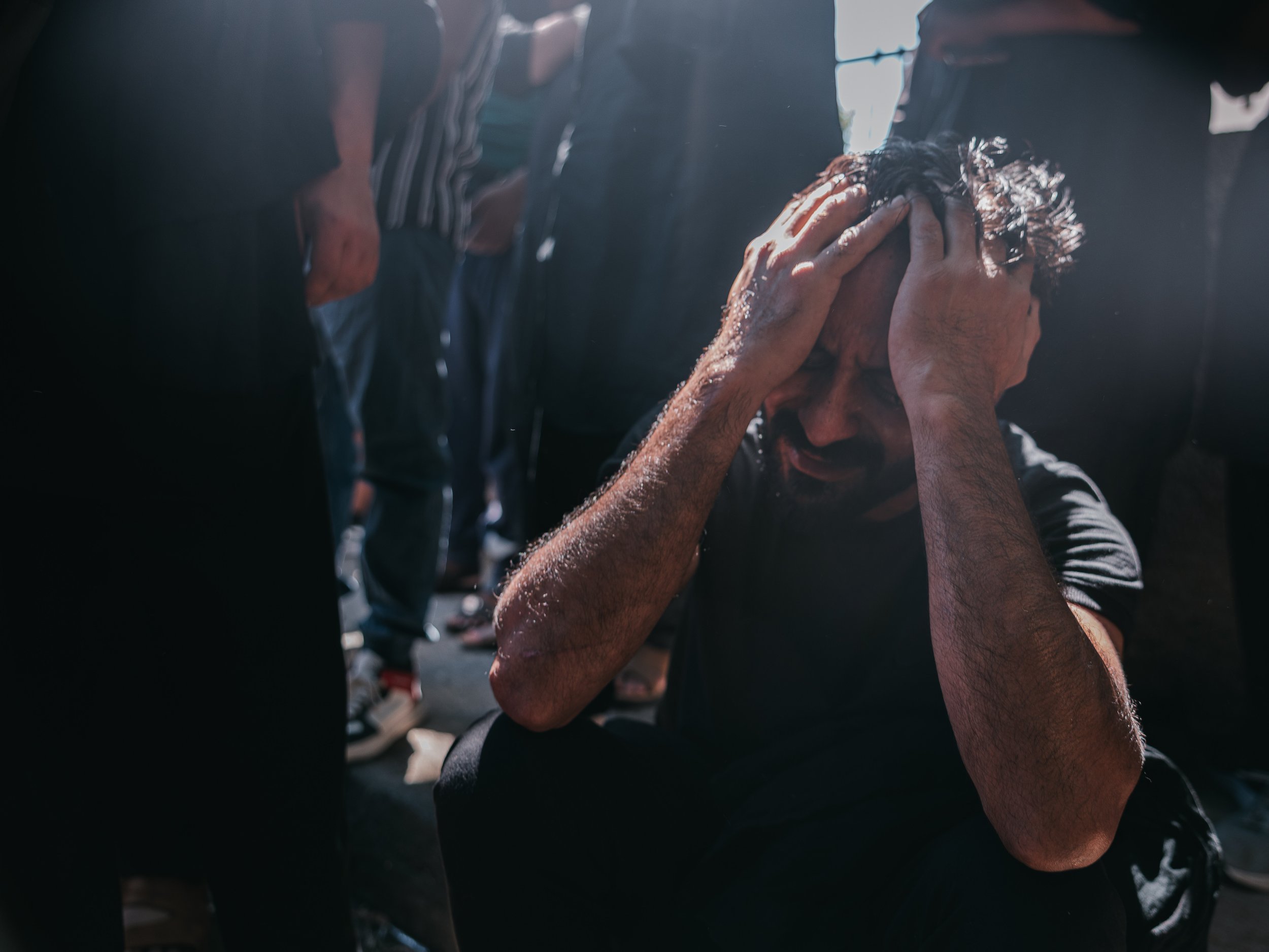 A man cries with his hand on his head during prayer outside the self-organized Shi’a mosque in Peristeri, Athens, Greece on July 6, 2025. The moment reflects the mourning and emotional devotion of participants commemorating the martyrdom of Imam Husa