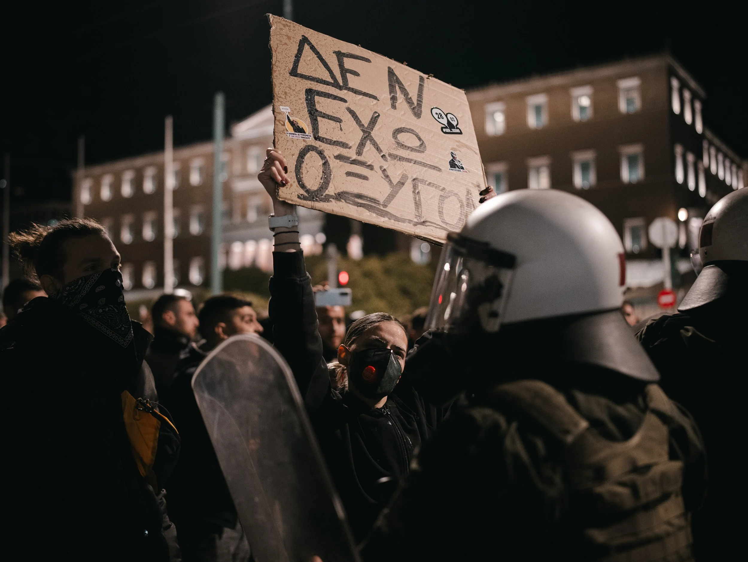 A girl holds a banner reading "We have no air" in front of riot police at Syntagma square.