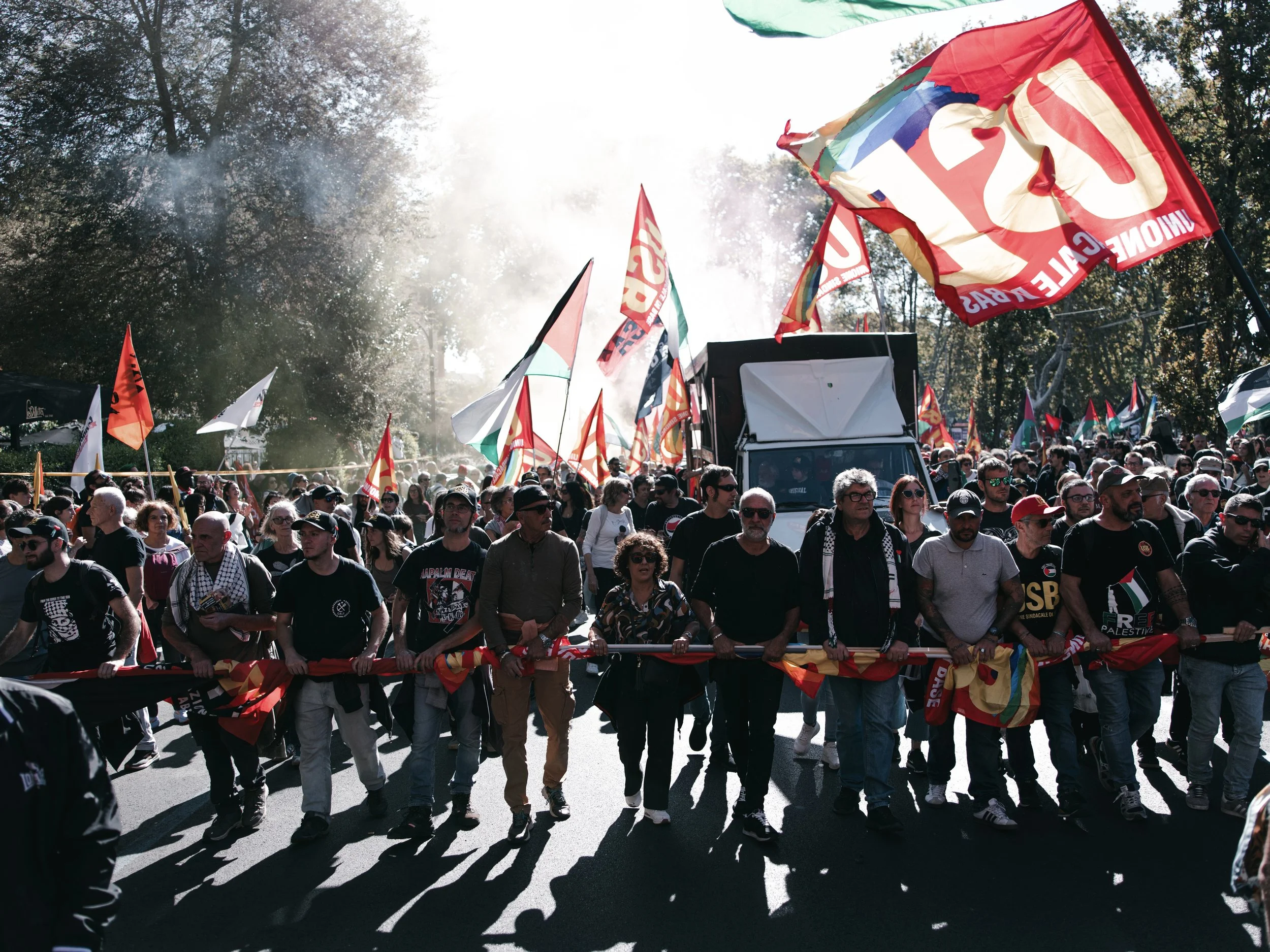 Protesters hold rolled flags while marching in a line during a pro-Palestinian rally in Rome, Italy on October 4, 2025. The march is part of a nationwide wave of demonstrations called after Israel intercepted the Global Sumud aid flotilla to Gaza, fo