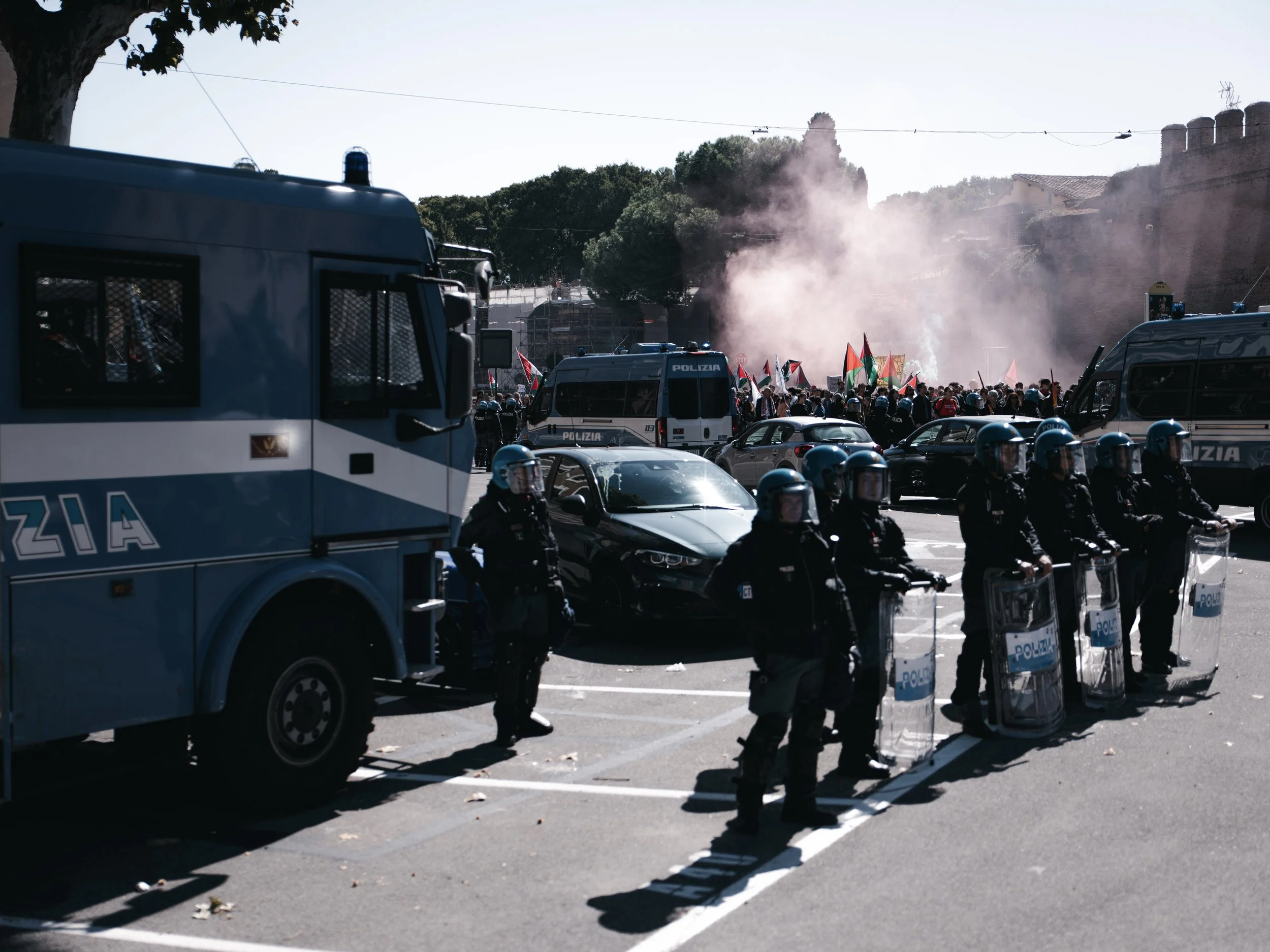 Police officers guard the Ministry of Infrastructure while protesters march nearby, waving Palestinian flags and burning smoke flares in Rome, Italy on October 3, 2025. The demonstration was part of a 24-hour national strike called by unions in solid