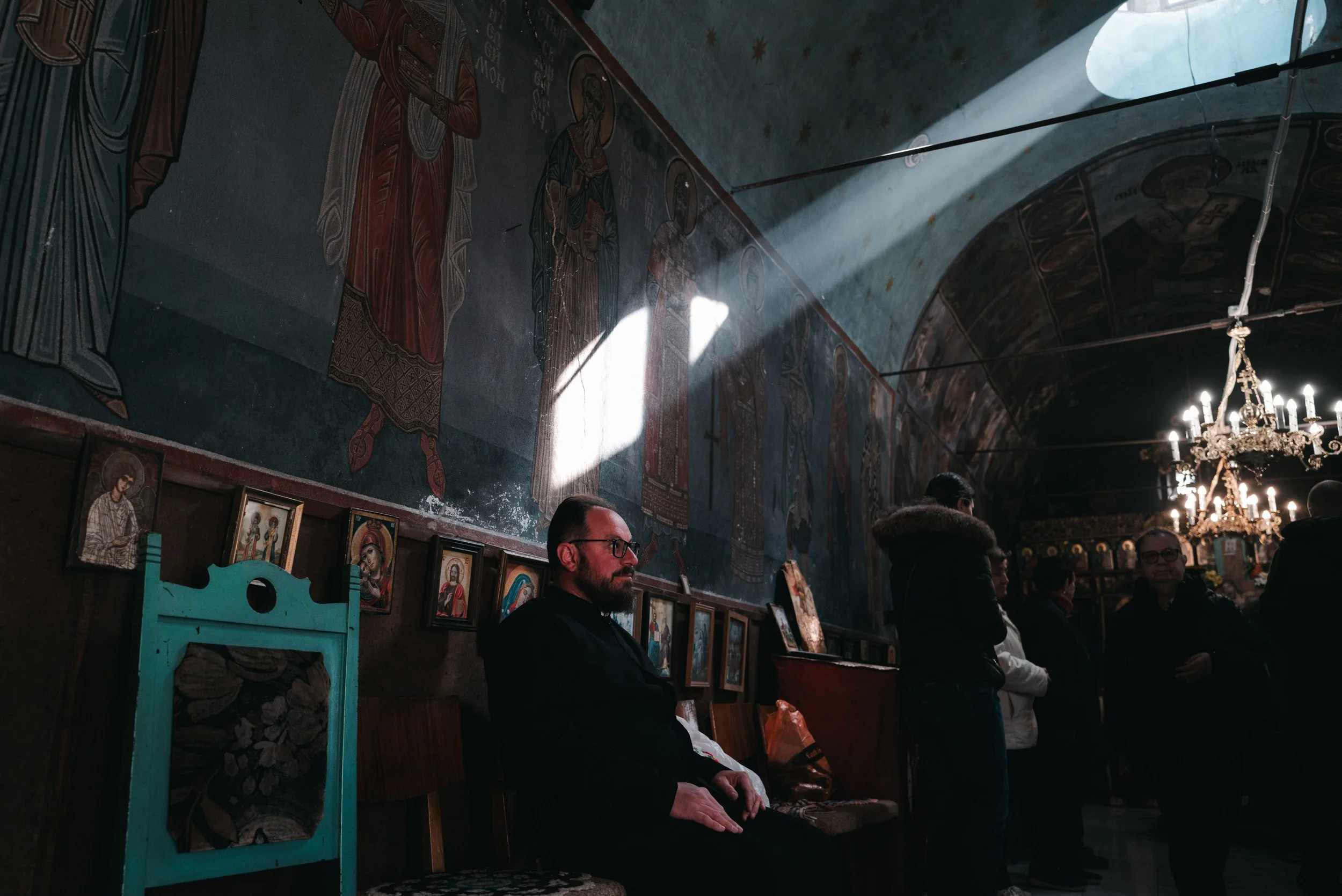 Archimandrite Januarij, abbot of Iskrets Monastery, sits on a chair inside the church in Iskrets, Bulgaria on April 10, 2026. The scene follows the morning Good Friday liturgy and the procession of the Holy Shroud, marking the Orthodox commemoration 