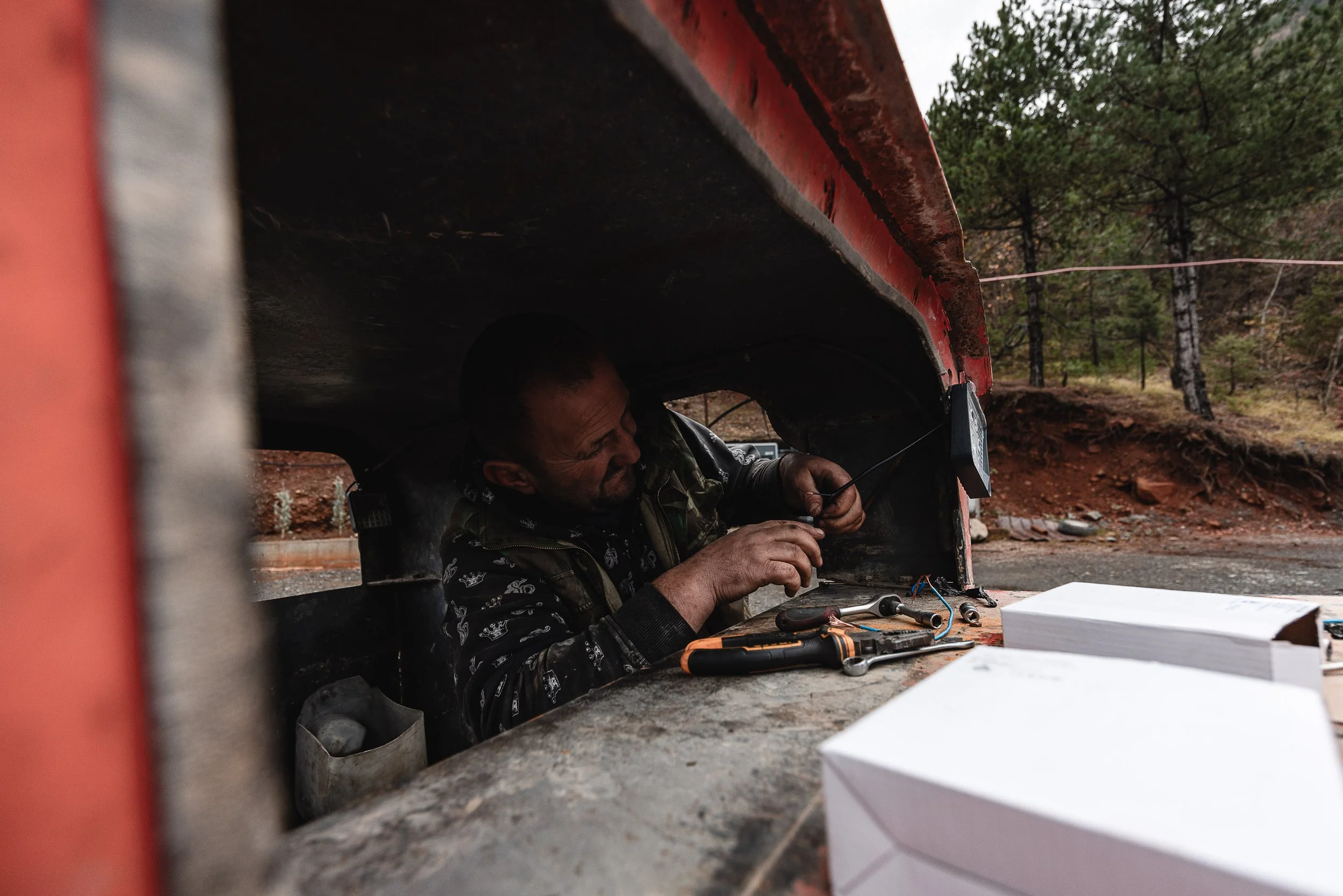 A man repairs a mining cart in front of the mine in Bulqizë, Dibër County, Albania on November 11, 2025. The work is part of maintaining equipment essential for the extraction and transport of chromium ore in the mining operation.