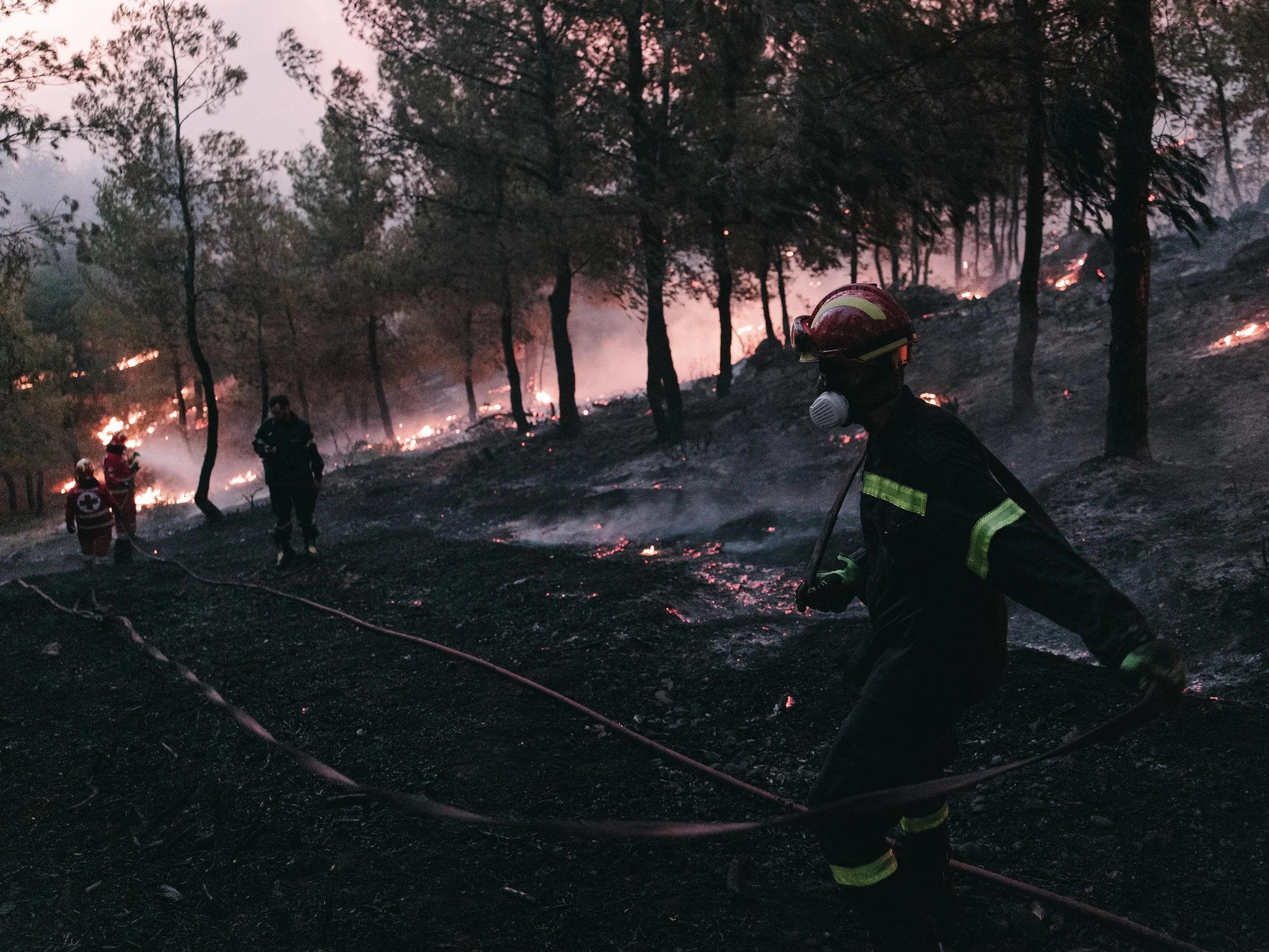 Firefighters and Red Cross crews deployed in the forests near Asprohori, working to contain the wildfire and prevent it from spreading toward nearby homes in northeastern Attica, in Asprohori on July 9, 2025.