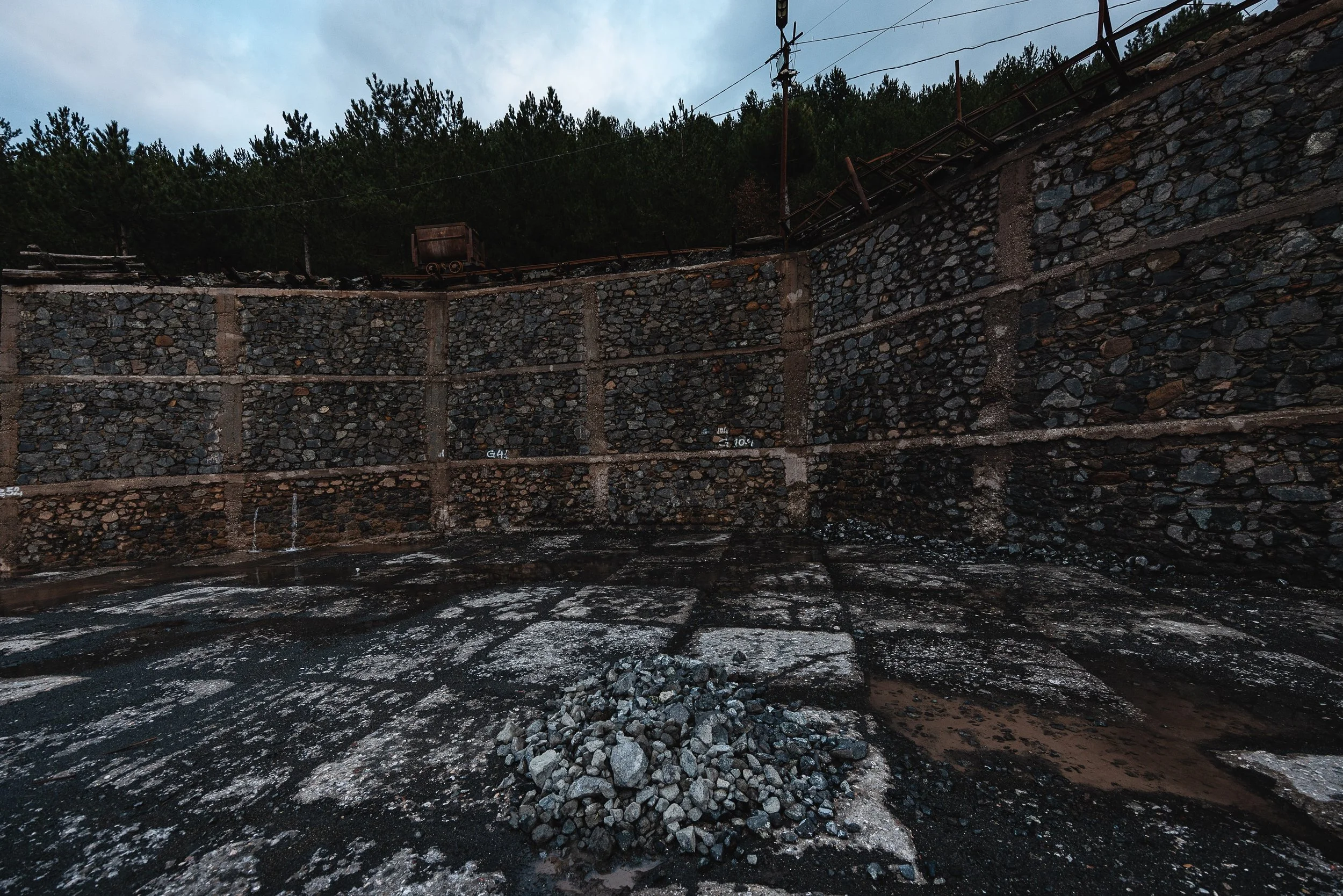 A retaining wall channels draining water next to the mine in Bulqizë, Dibër County, Albania on November 11, 2025. The structure is part of the mine’s infrastructure, managing water flow to prevent flooding and support ongoing chromium extraction.