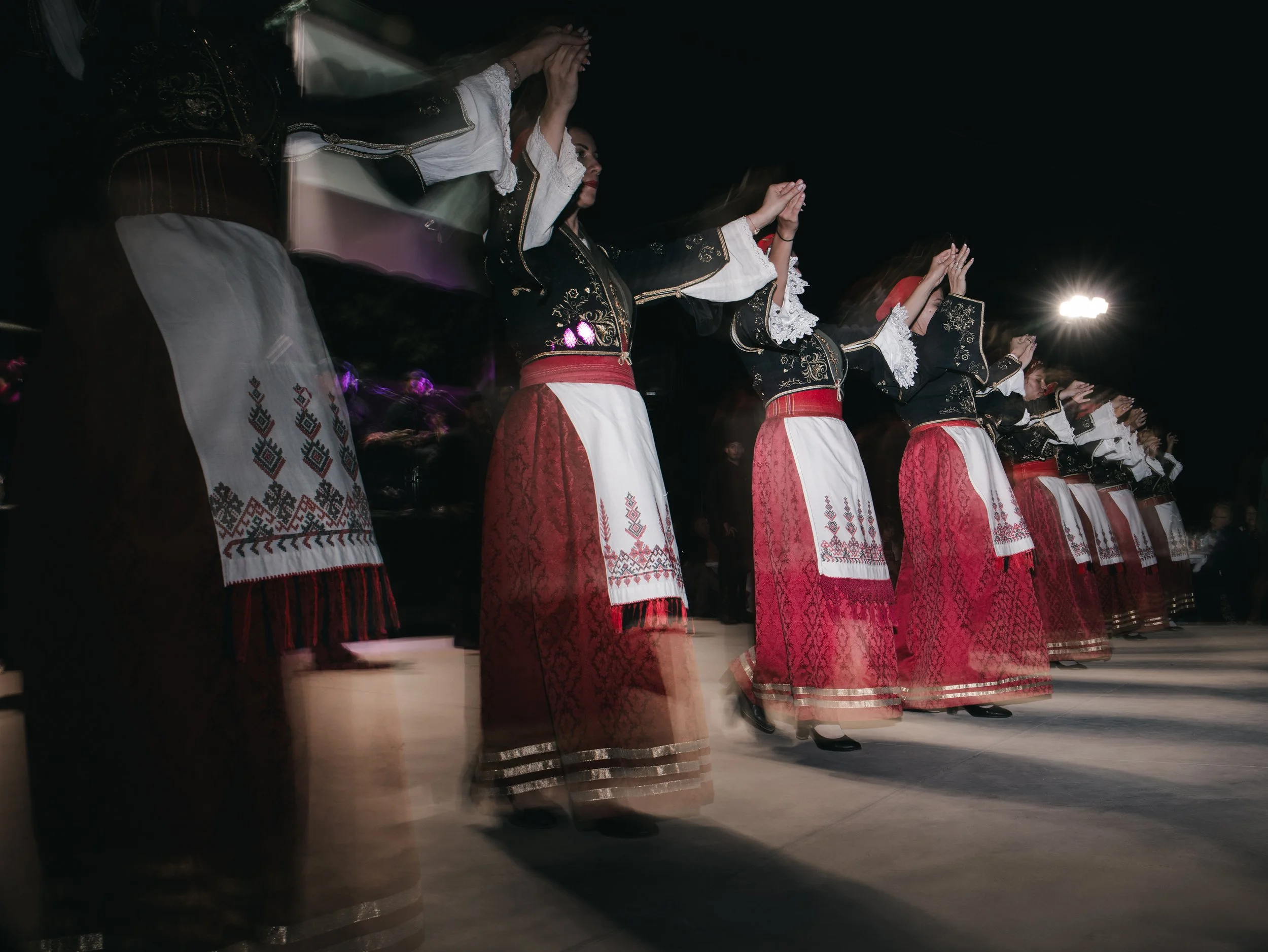 Women dance in a line during a panigiri, a village festival featuring music, food and dance that is rooted in Orthodox religious celebrations and local traditions. Skines, Crete, Greece, August 21, 2025.