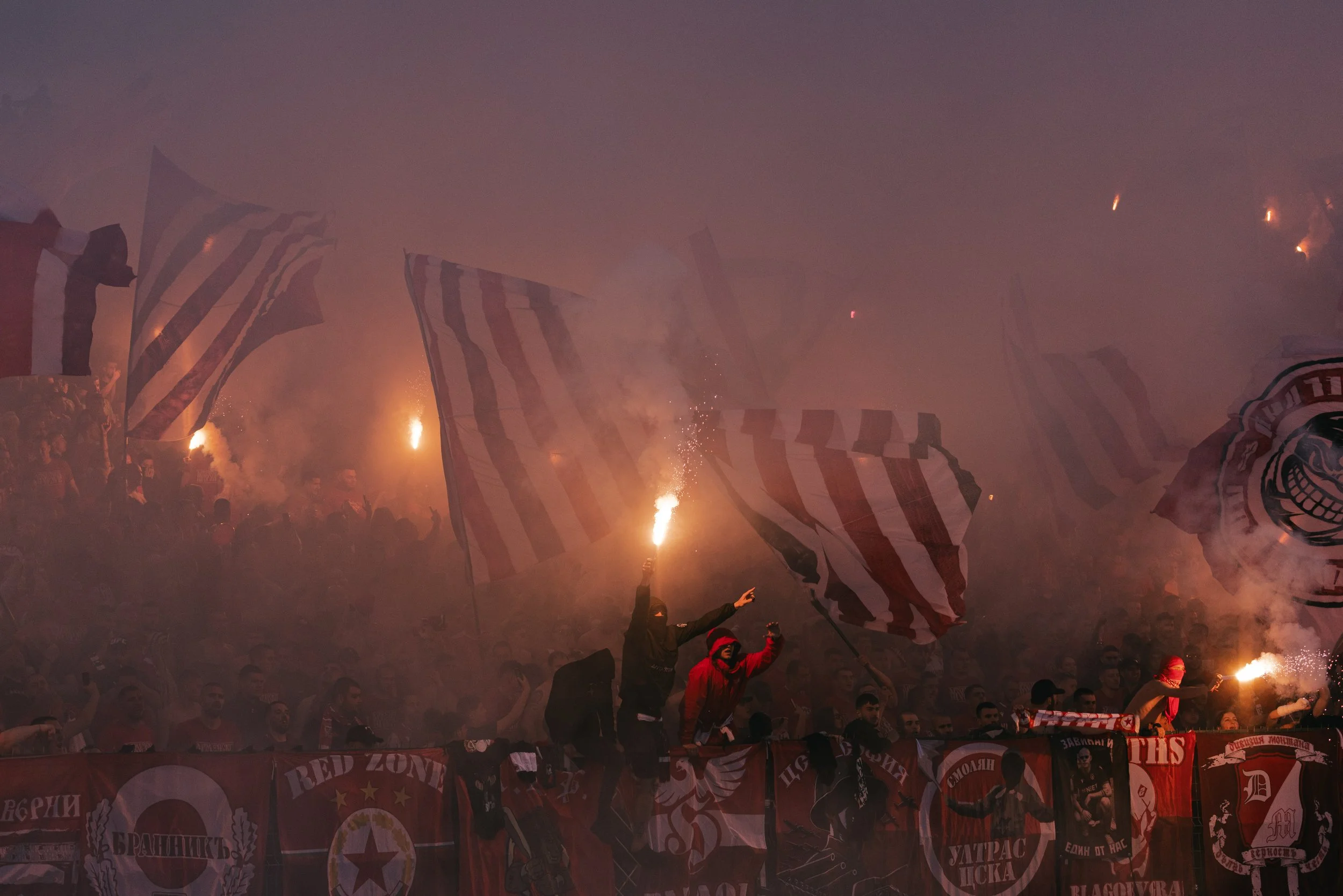 CSKA Sofia supporters light red flares and wave flags while standing above barriers covered with CSKA Sofia banners during the Bulgarian Cup Final at Vasil Levski National Stadium in Sofia, Bulgaria on May 20, 2026. 