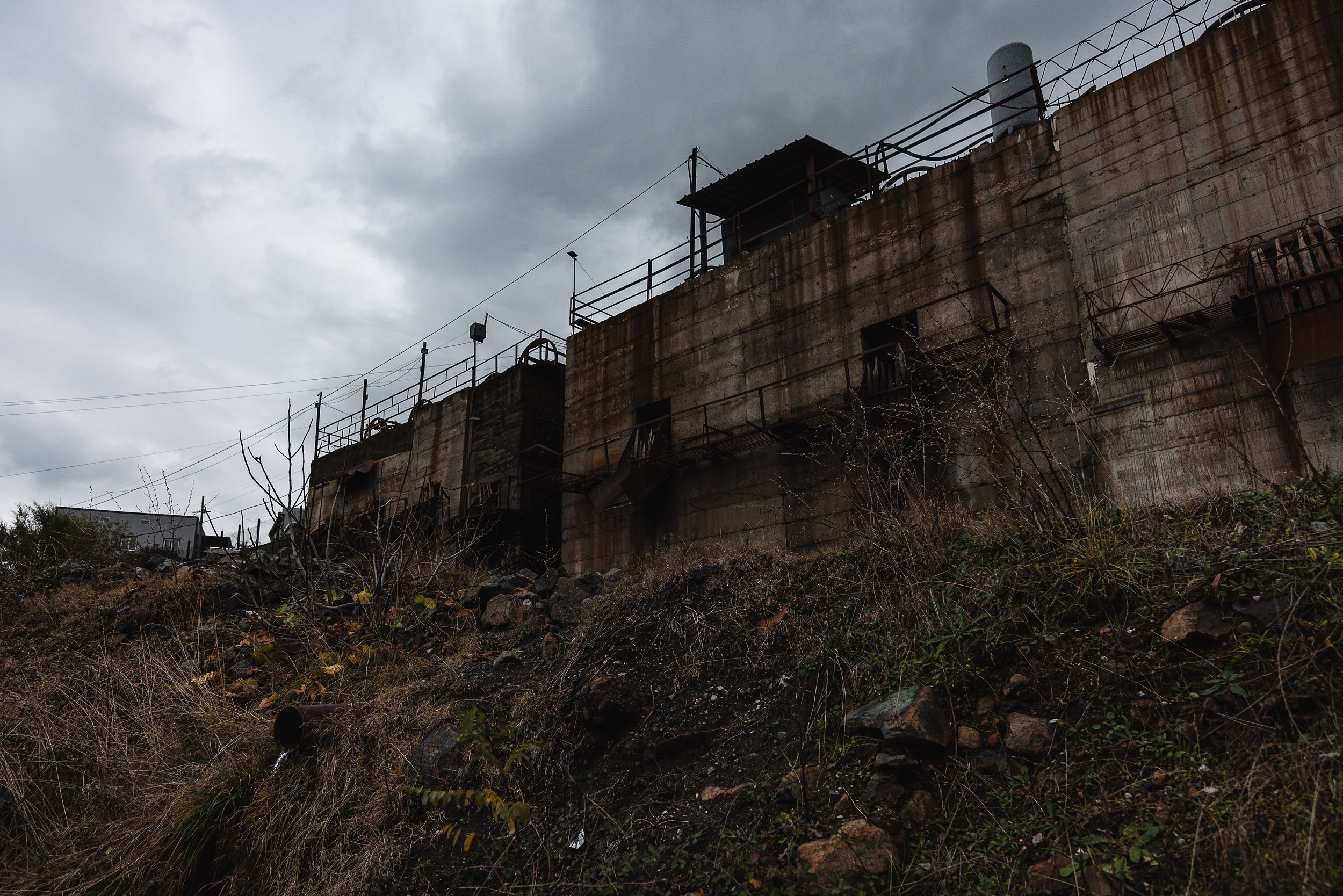 An old building, part of the mining industrial complex, stands along the path to the mine in Bulqizë, Dibër County, Albania on November 11, 2025. The structure reflects the long history of chromium mining that has shaped the region’s economy and land