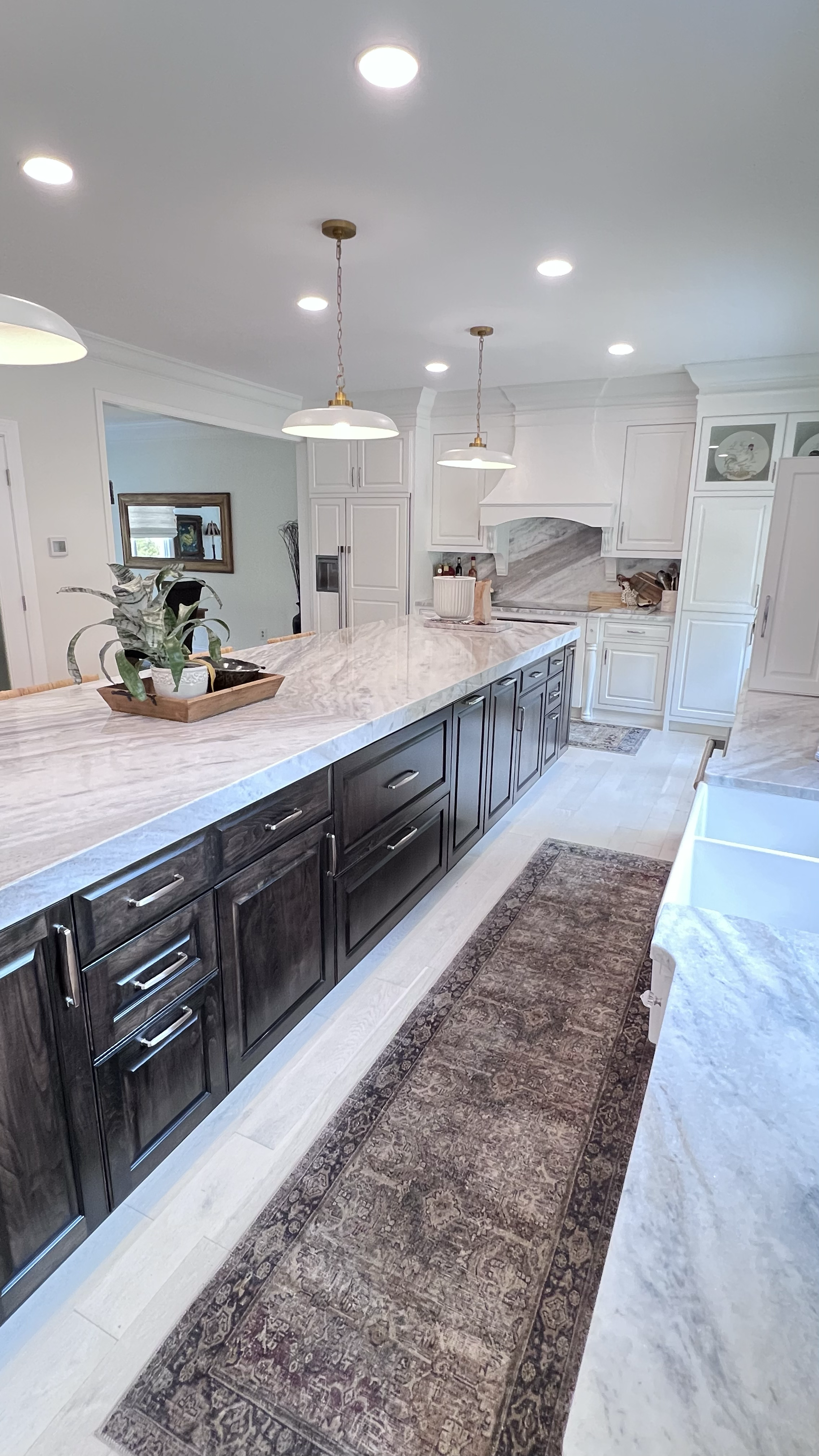 Kitchen island with granite countertop and custom cabinetry and built-in wine fridge.