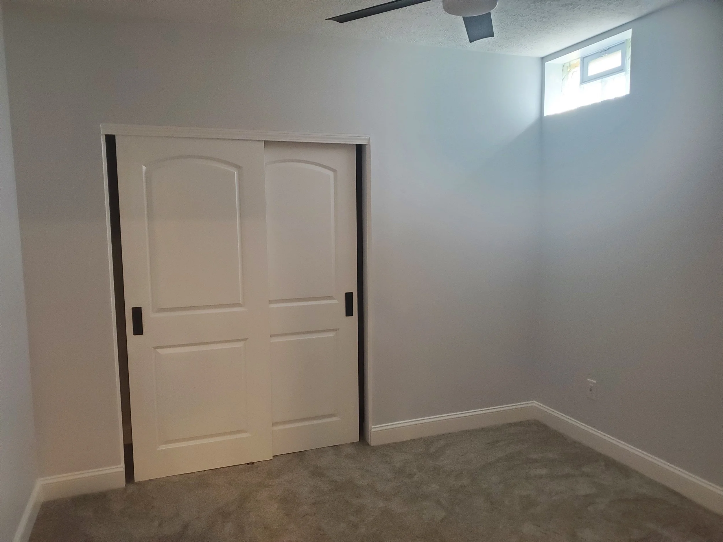 Basement bedroom remodeling with new carpet and closet doors.