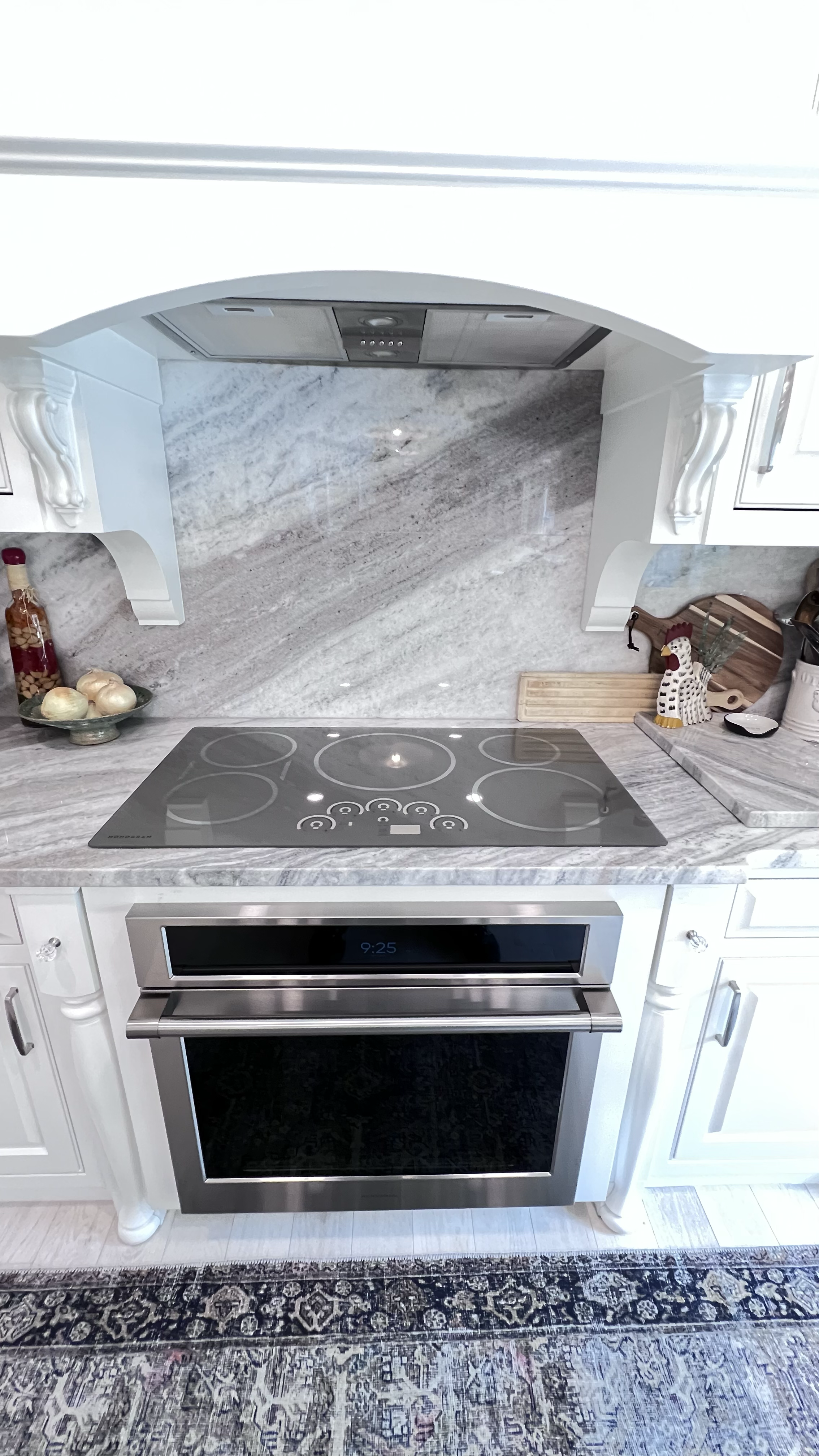 Kitchen remodel featuring marble slab backsplash and new stove and oven appliance.
