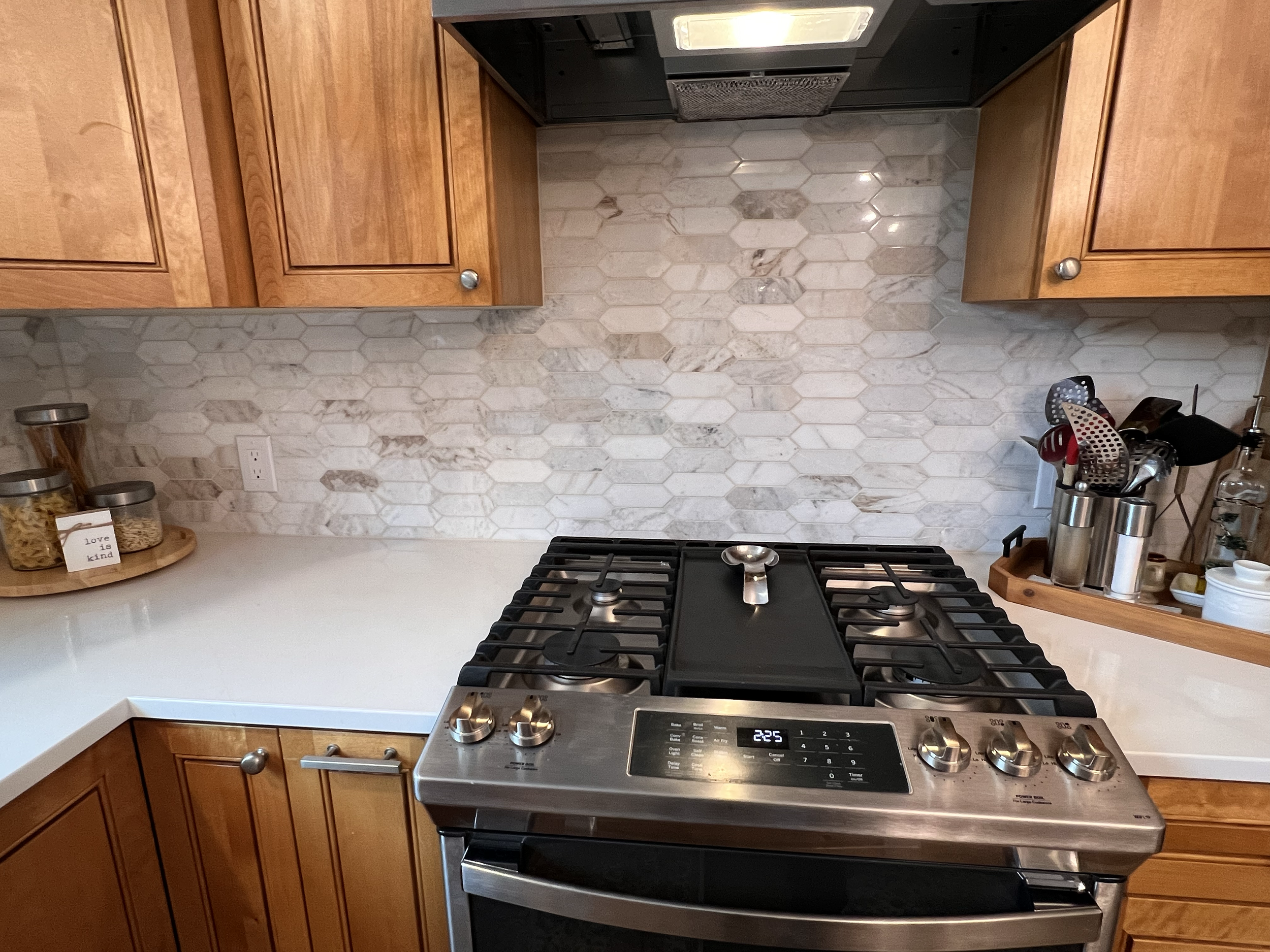 Kitchen tile backsplash remodel and updated gas stove and cherry wood kitchen cabinets. 