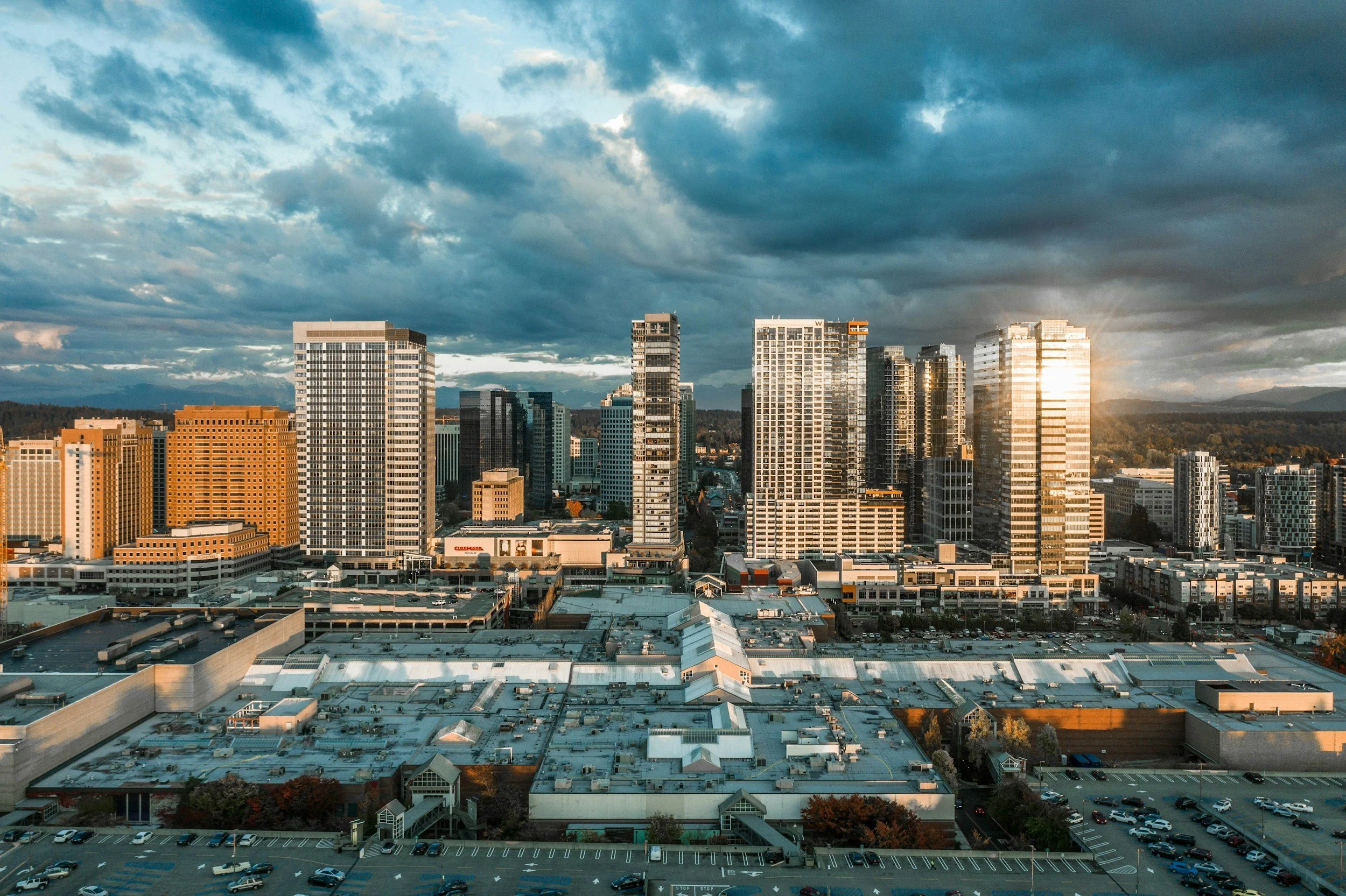 Aerial view of a Washington city skyline with glass high‑rise buildings under dramatic clouds.