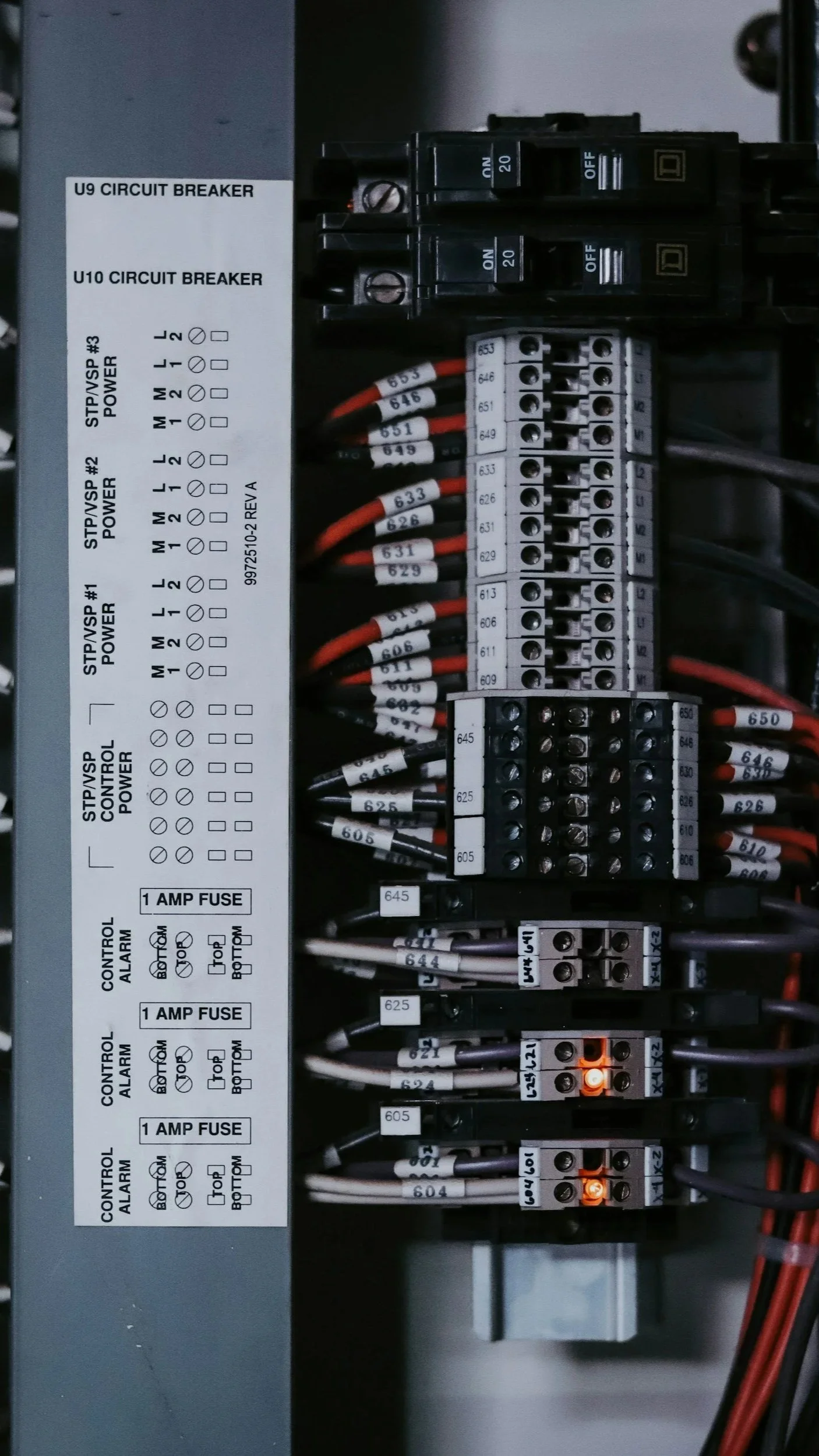 Close-up view of an electrical panel with circuit breakers, wiring, and an informational label.