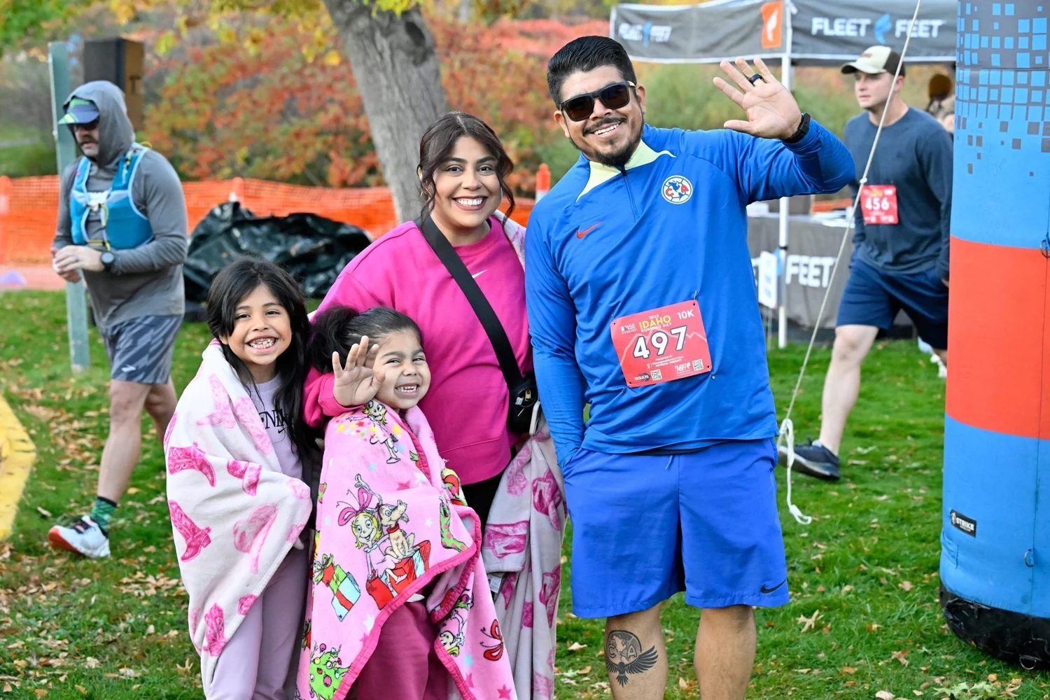 A family waves at the camera at the Idaho Running Day finish area