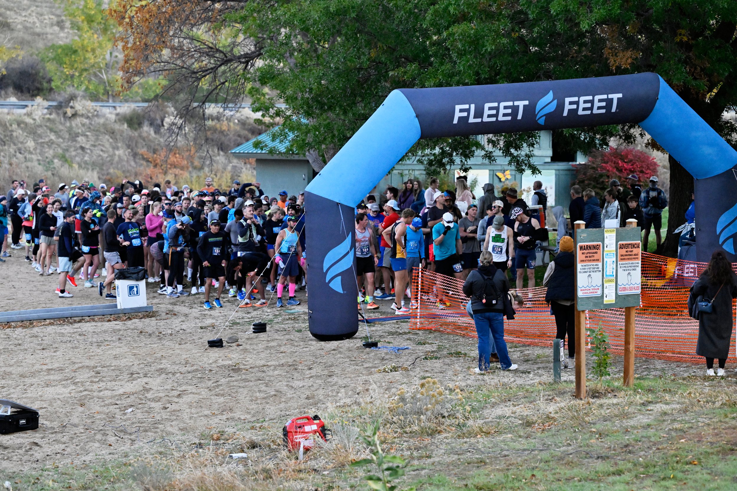 A crowd of runners heads out at the start of a Boise Running race