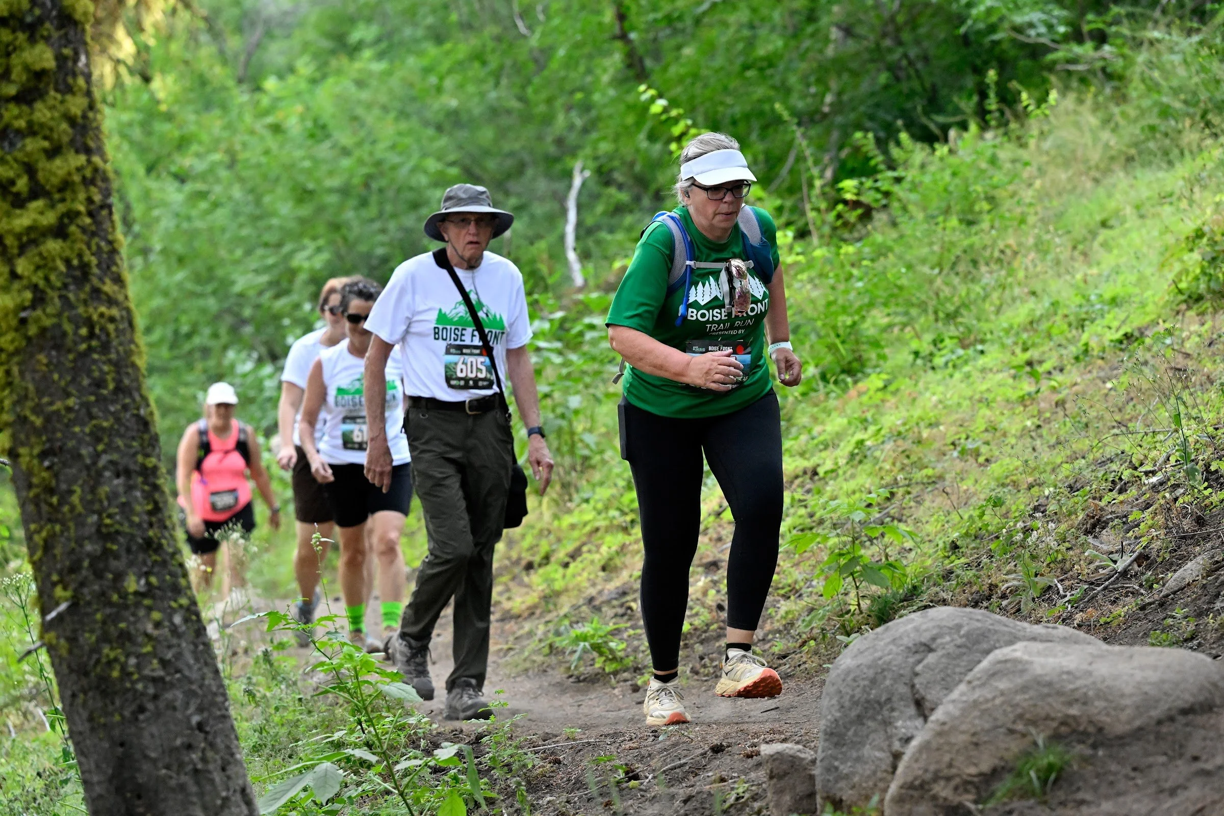 Friends hike together up a forested trail during the Boise Front Trail Festival