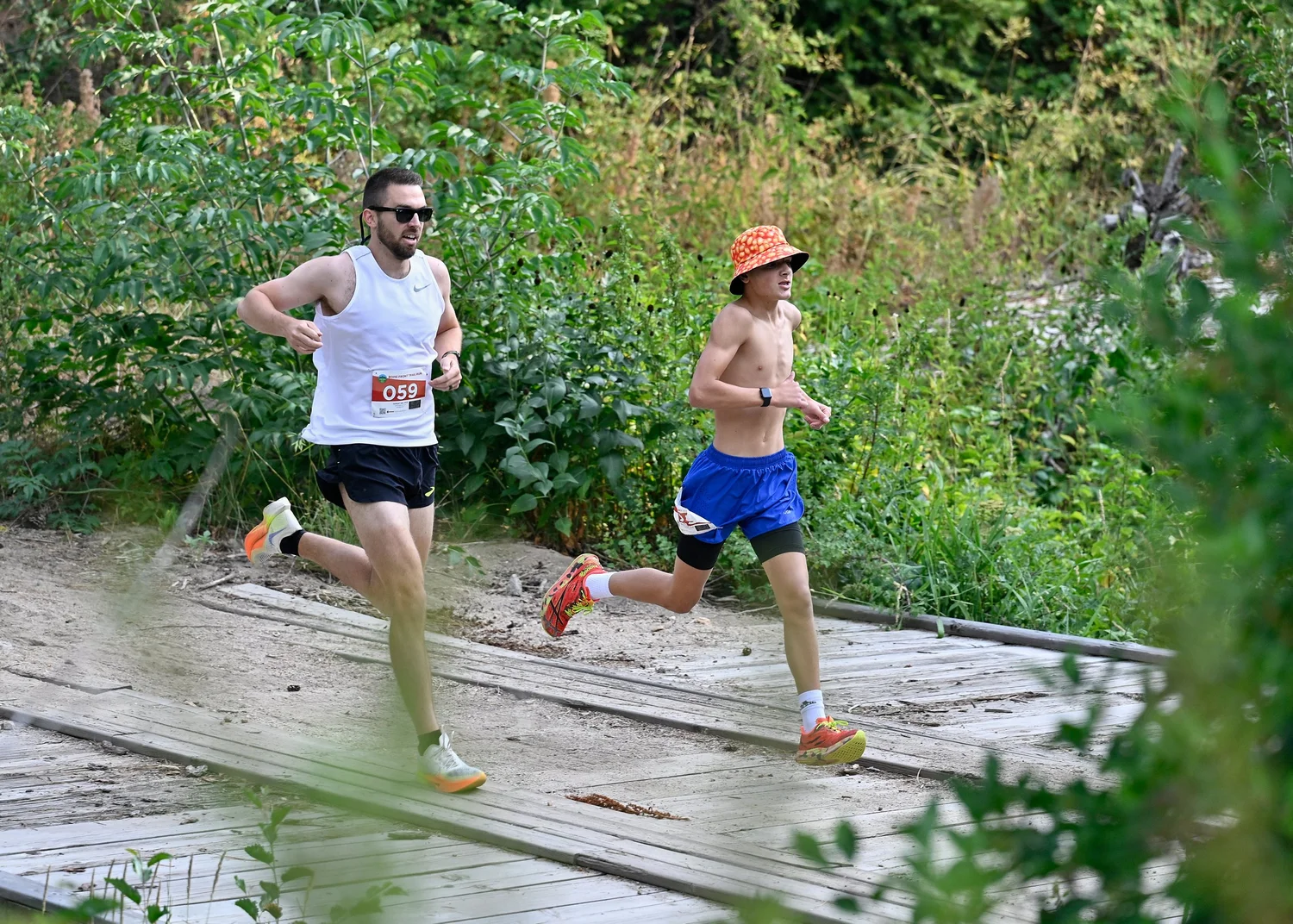 Two trail runners cross a wooden bridge on the Boise Front Trail Festival course