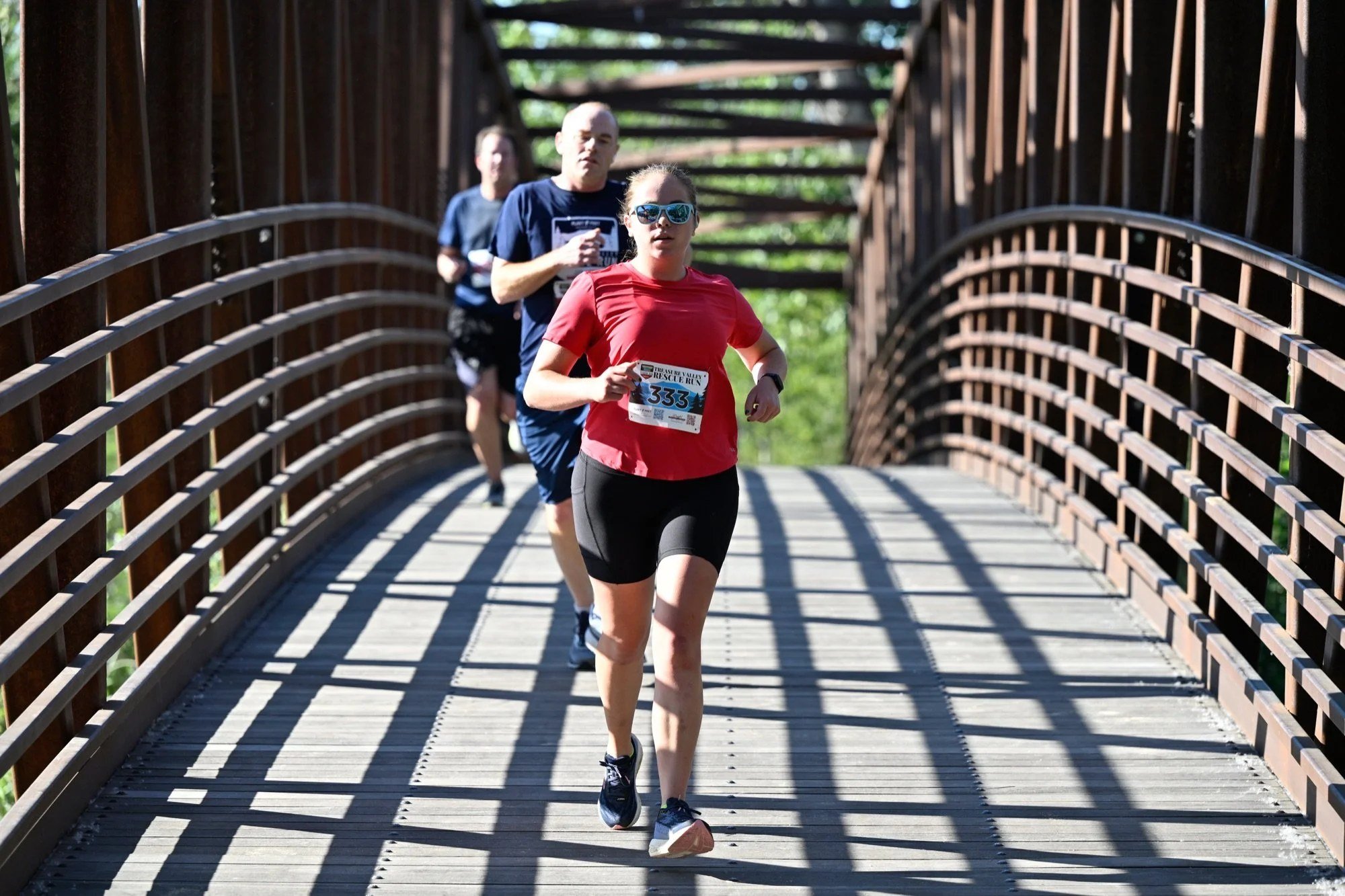 Runners cross a Greenbelt bridge over the Boise River in Eagle