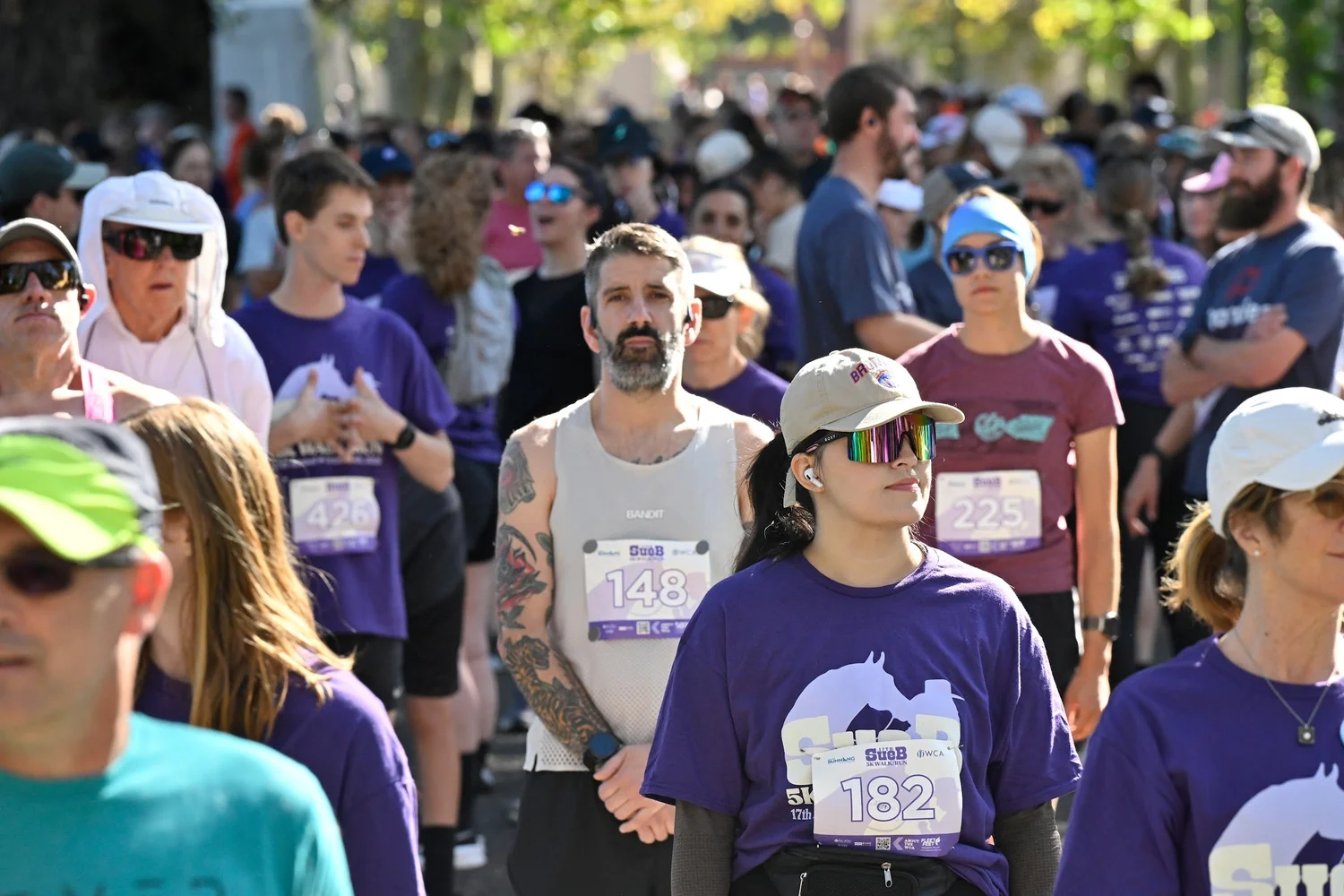 A crowd of SueB walkers and runners in purple at the start