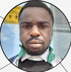Close-up of a young man with dark skin, wearing a green and white jacket over a collared shirt.
