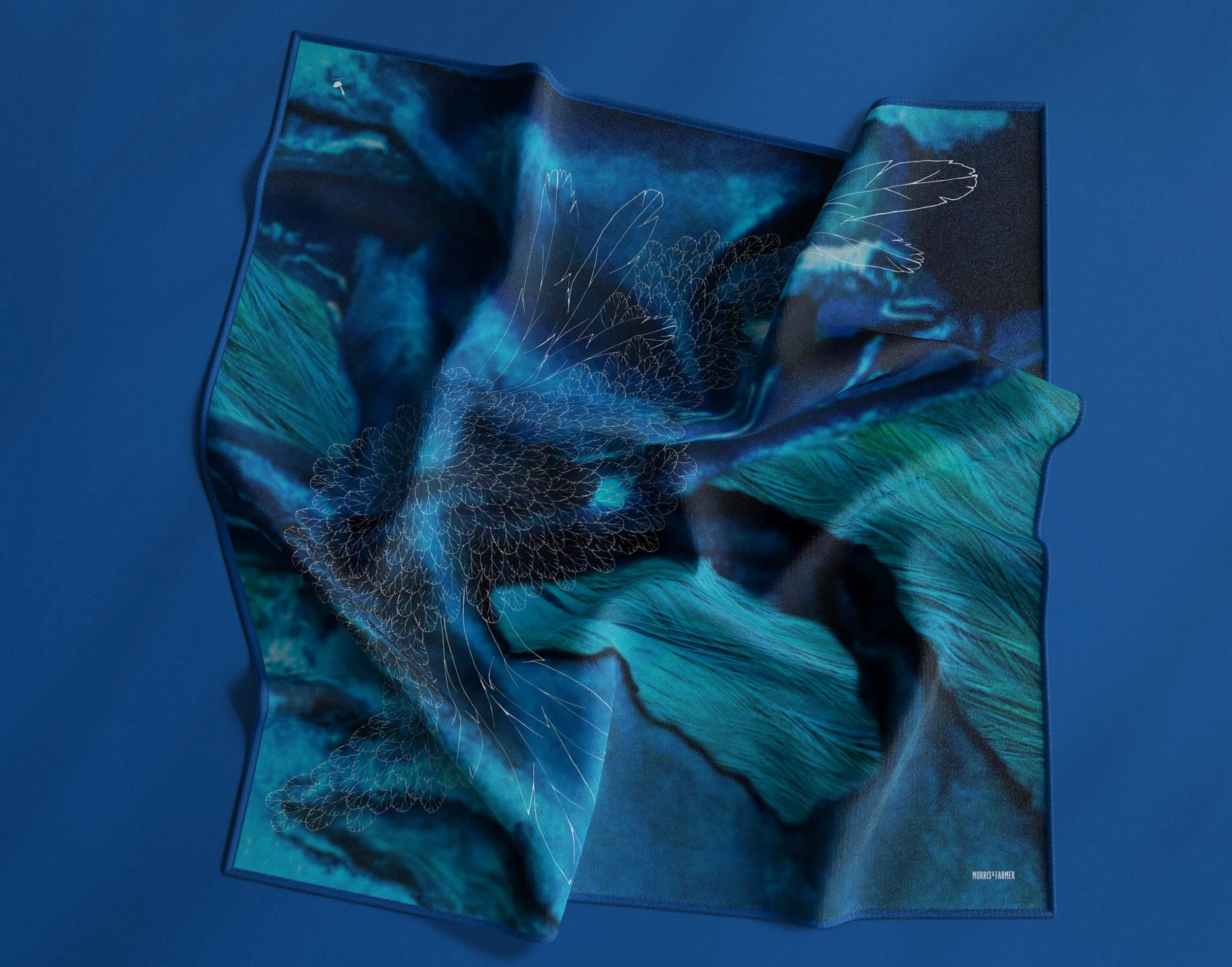 An open, folded fabric with a vibrant blue and teal abstract floral design on a solid blue background.