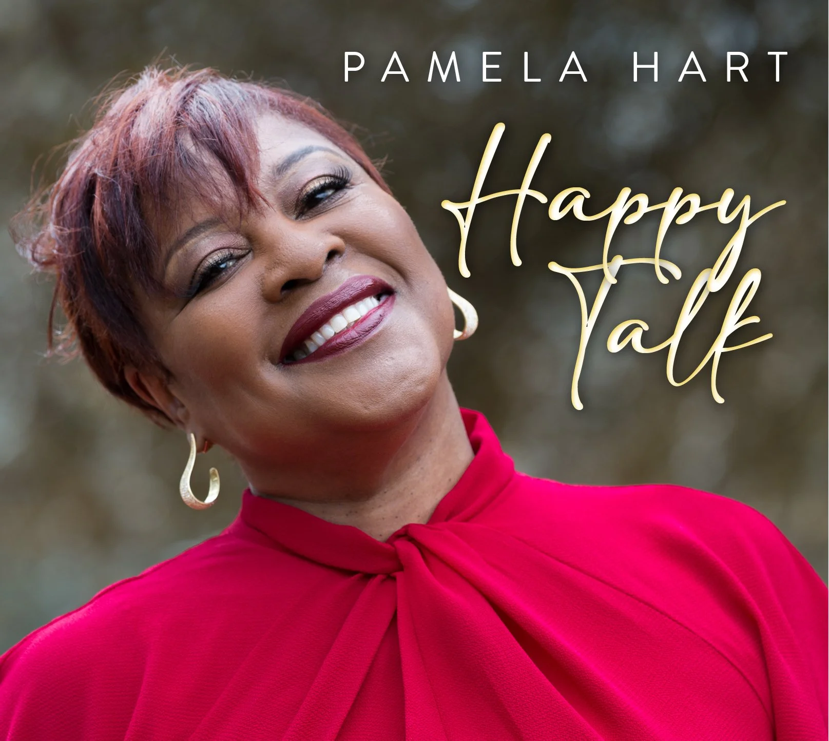 Close-up of a smiling woman with short reddish-brown hair, wearing a red top with a bow at the neck and gold earrings, outdoors with blurred background, with text saying "Pamela Hart" and "Happy Talk".