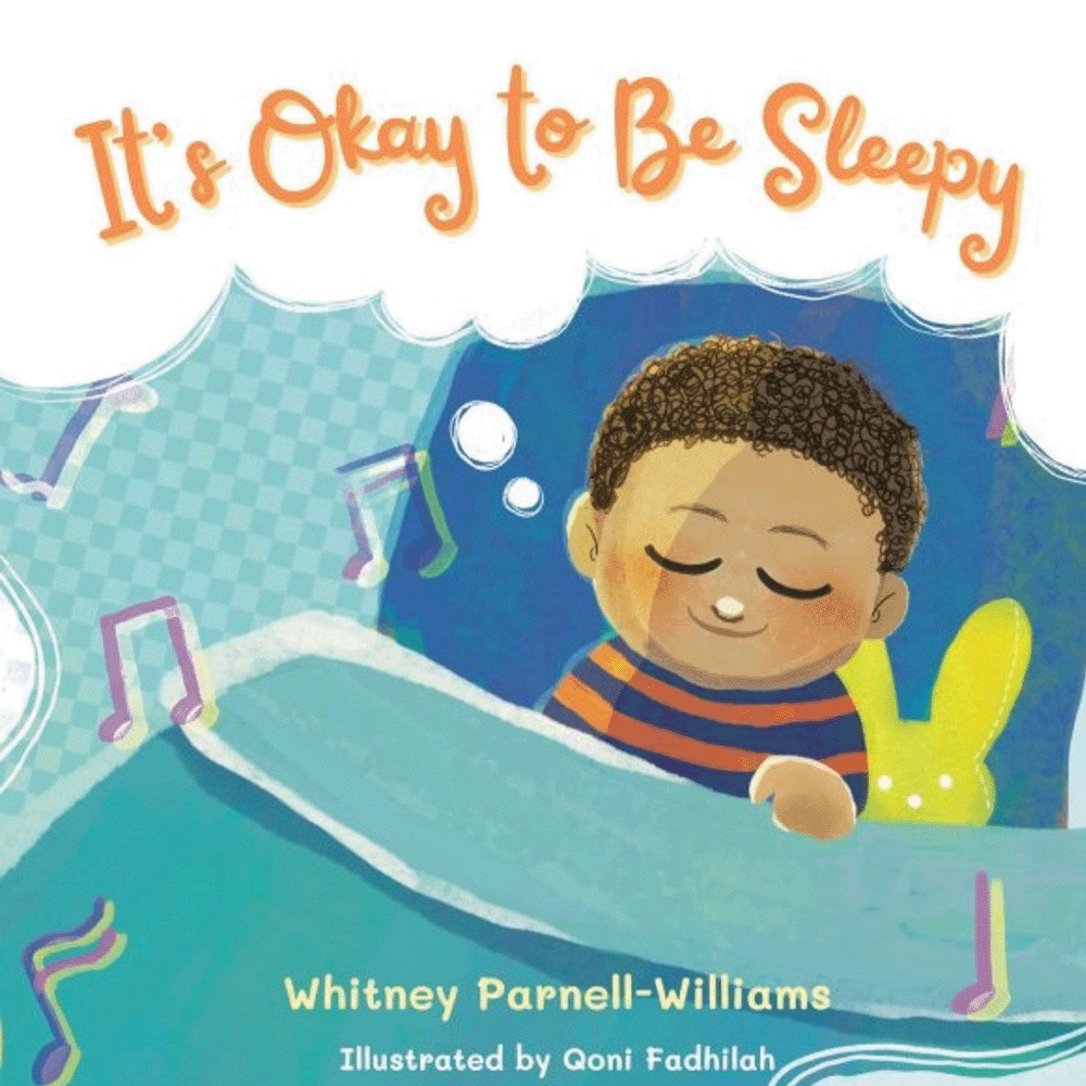 Cover of a children's book titled "It's Okay to Be Sleepy" showing a smiling child with curly hair in pajamas, lying in bed with a blue blanket and a yellow bunny-shaped pillow, surrounded by floating musical notes and a cloud with the title text.