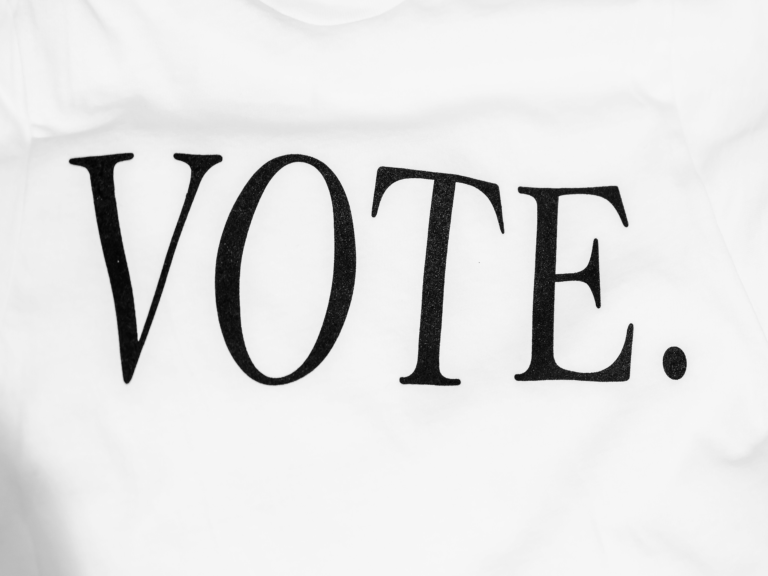 Black text that reads 'VOTE.' on a white background.
