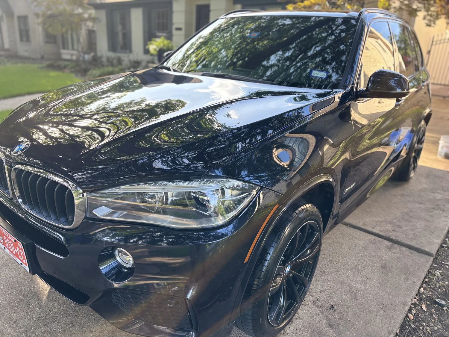Black BMW SUV with a glossy ceramic-coated finish after White Slate detailing