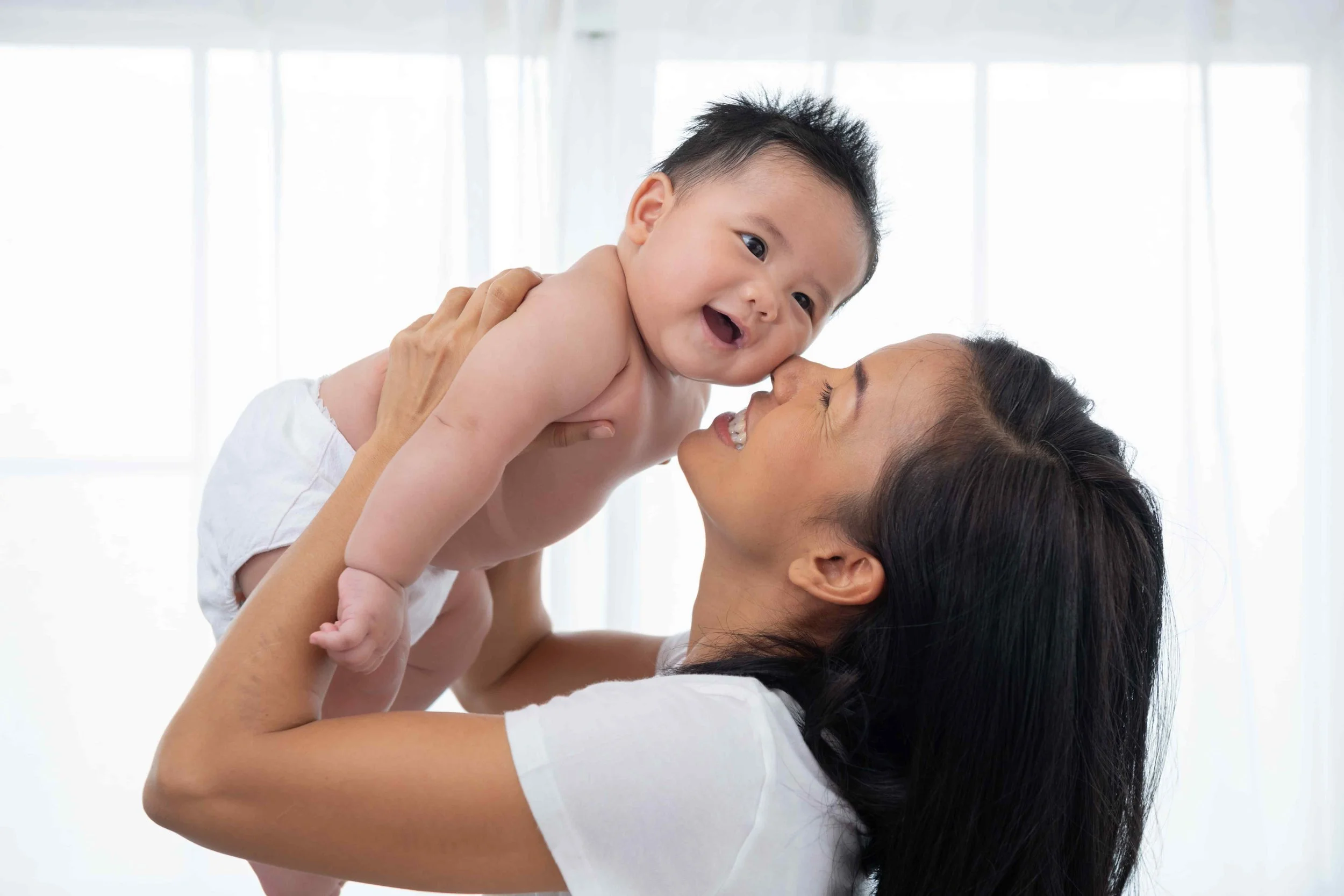 a mother lifting her baby