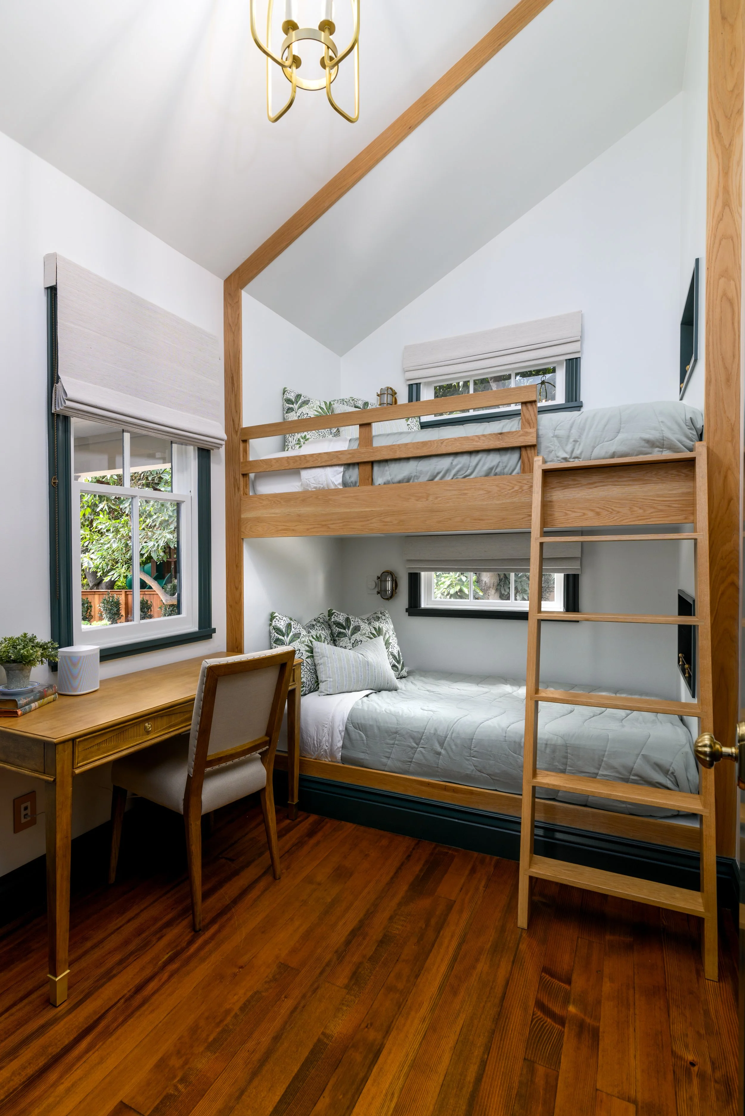 Custom bunk room with built-in wood beds, workspace, and guest-friendly design for a family vacation home