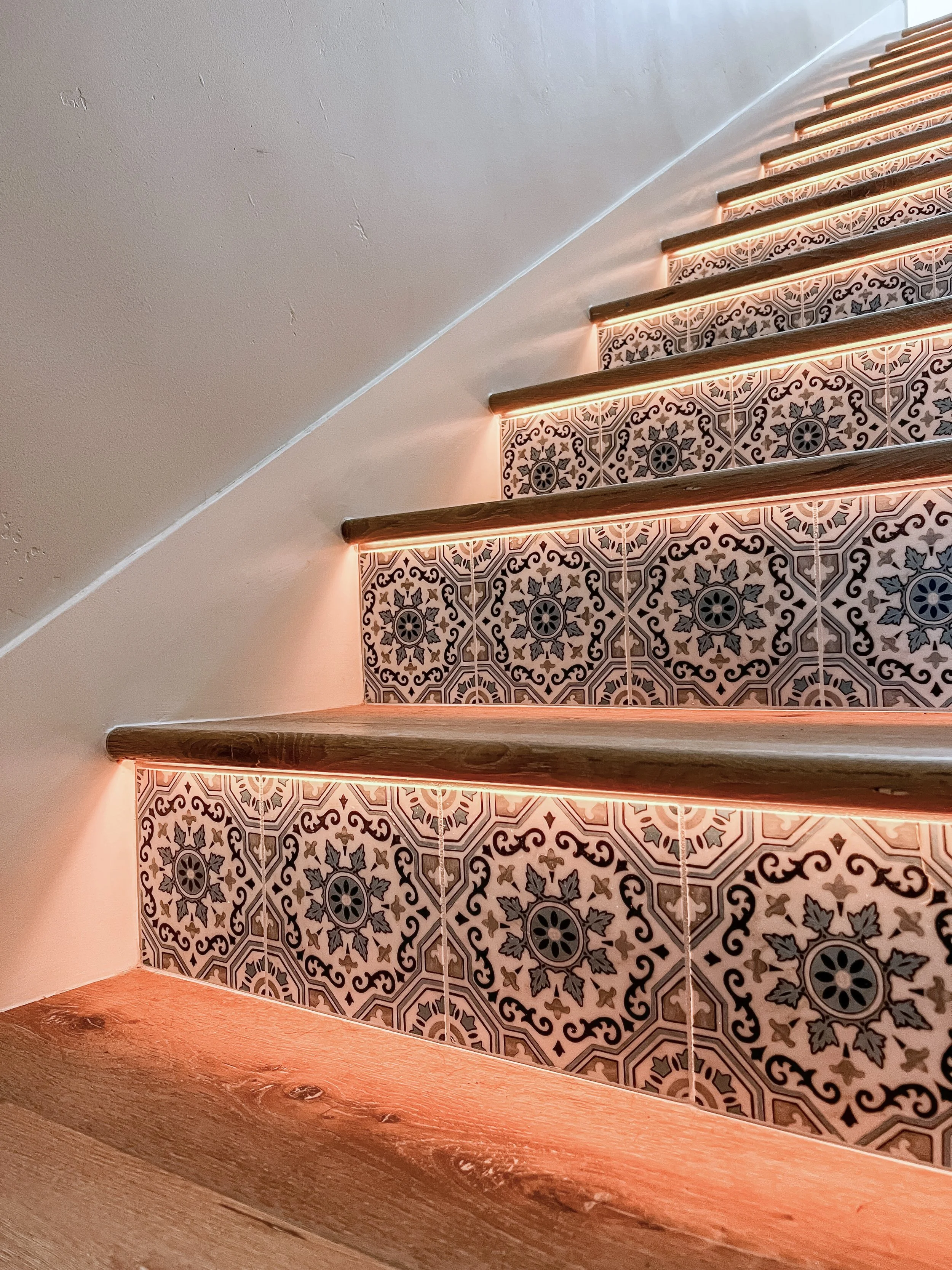 Staircase with integrated stair tread lighting and patterned risers to improve visibility and safety in aging-in-place home design.