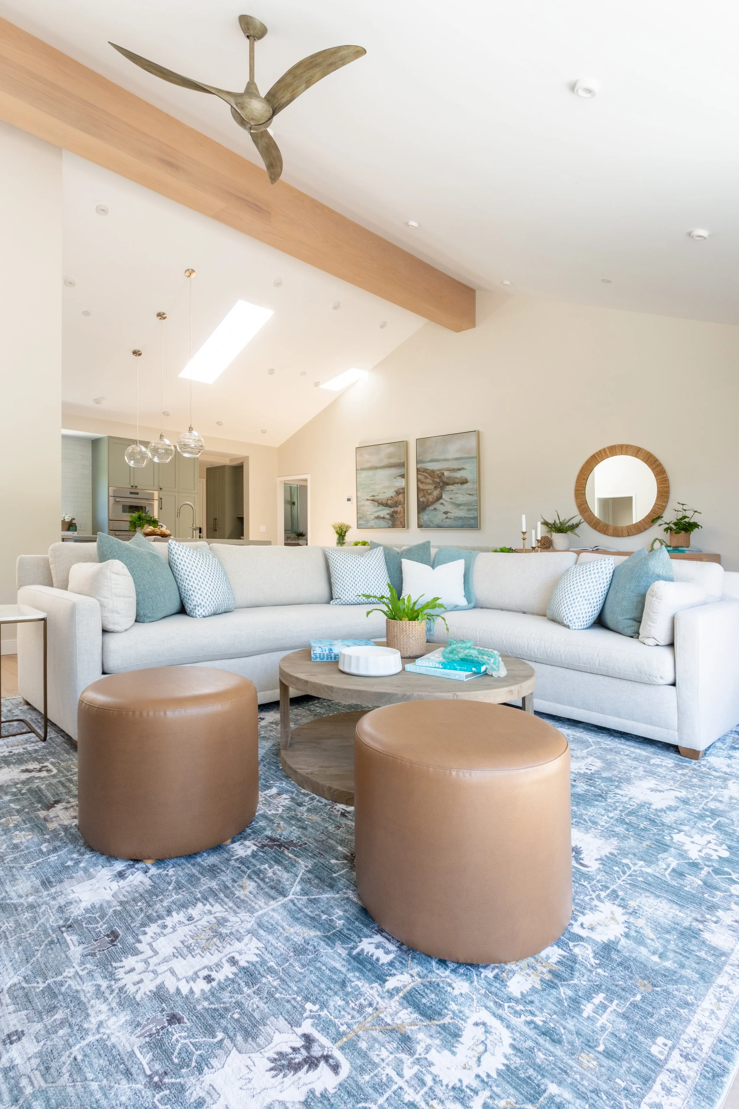 Bright California vacation home living room with sectional seating, coastal blue accents, and natural wood details