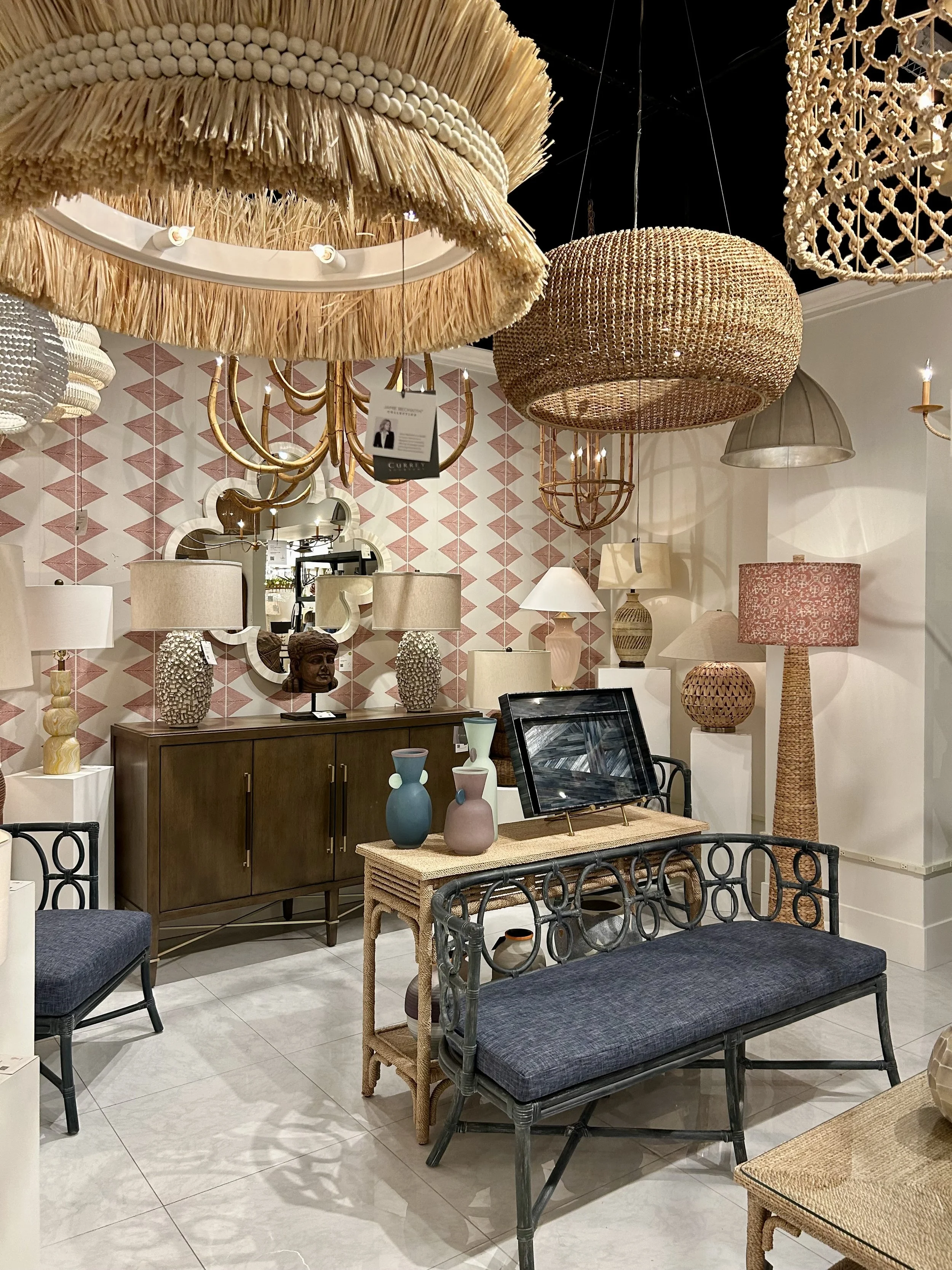 Display of oversized woven pendants, textured lamps and warm wood furniture at Las Vegas Market.