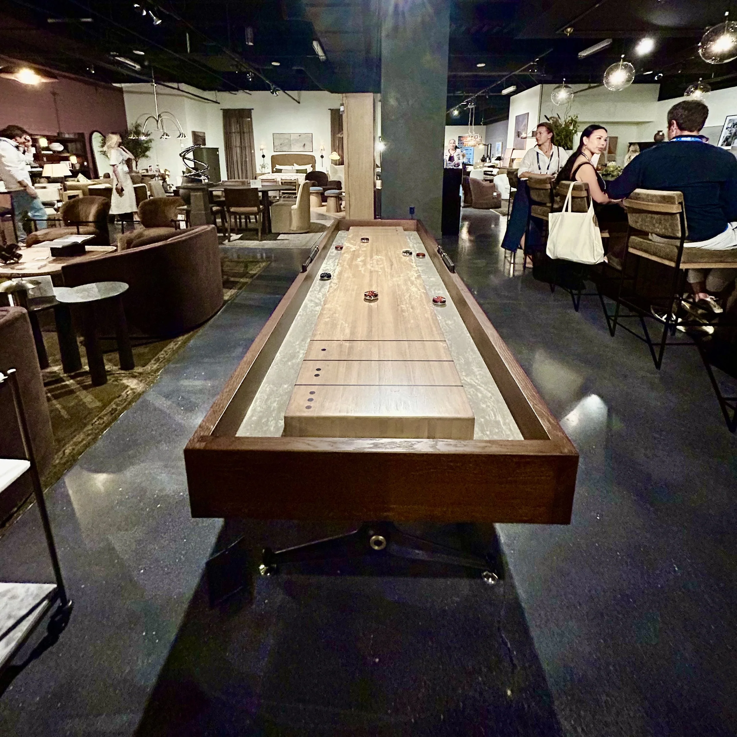 Warm wood shuffleboard table designed to blend with residential furnishings at Las Vegas Market.
