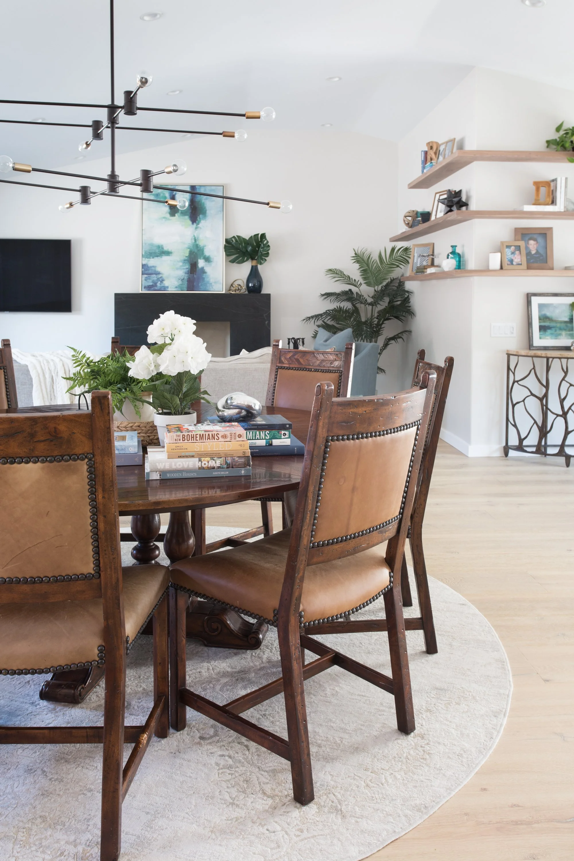 Dining room with vintage wood table, leather chairs, and styled centerpiece creating a warm and layered interior design look.