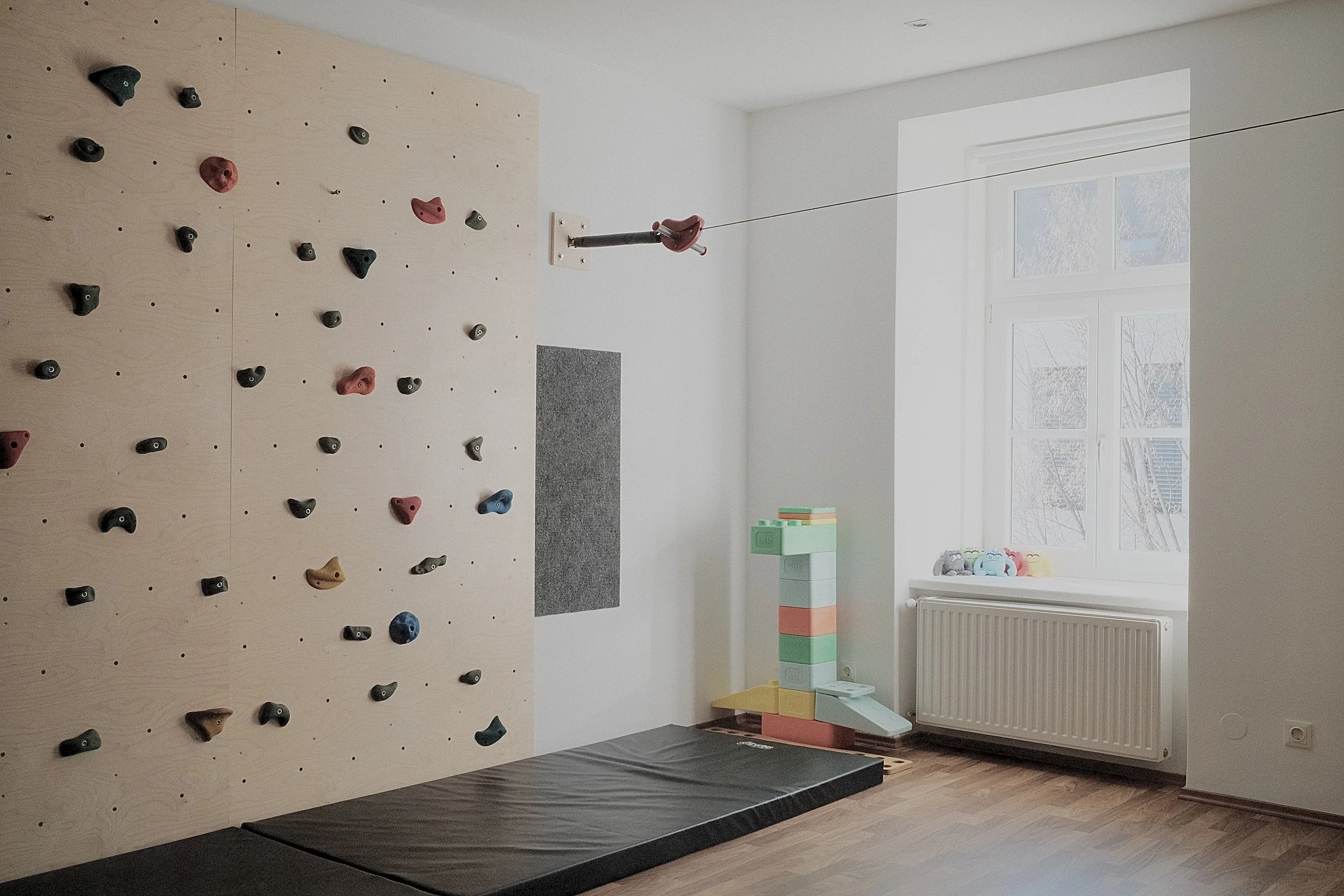 Der Therapieraum der Ergotherapie in Wiener Neustadt mit einer Kletterwand, welche zur Förderung der motorischen Fähigkeiten und Koordination bei Kindern genutzt werden kann.