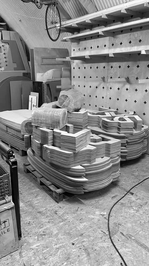Stacks of skateboard decks stored on pallets in a warehouse.