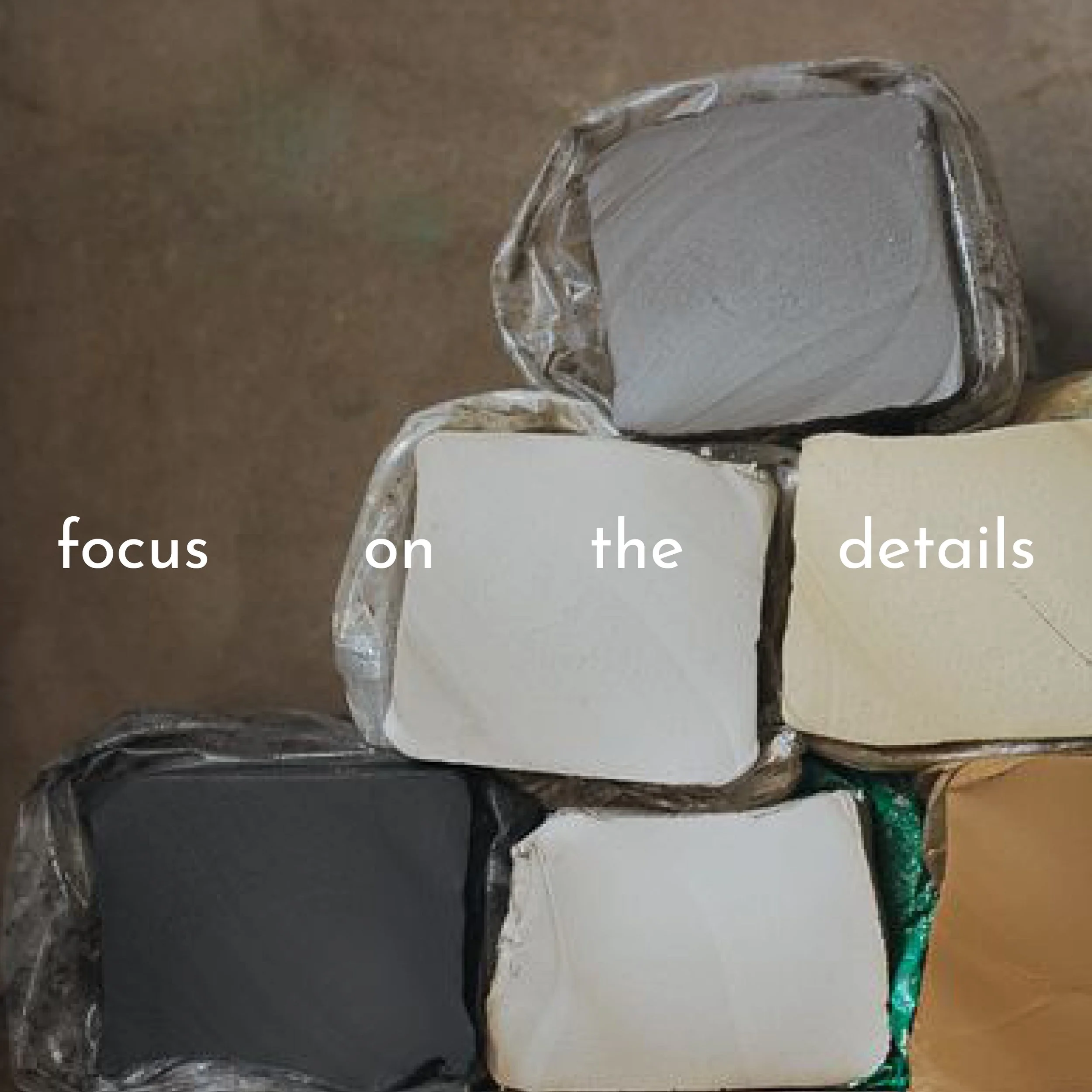 Mehrere Blöcke Ton oder Lehm in verschiedenen Farben übereinander gestapelt, mit dem Text "focus on the details" aufgedruckt.