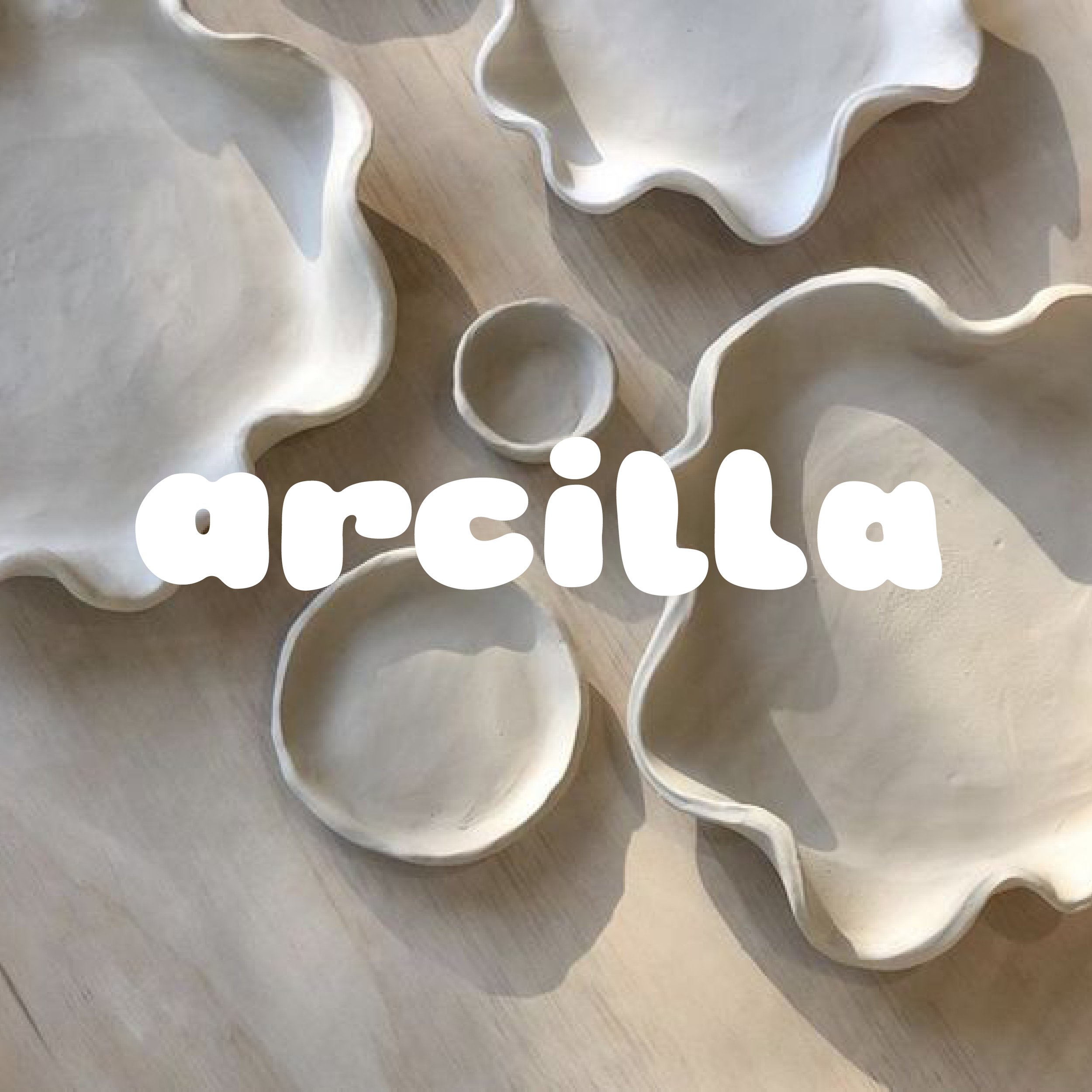 Ton-Schalen mit unregelmäßigen Kanten auf Holzuntergrund, Schriftzug 'arcilla' darüber.