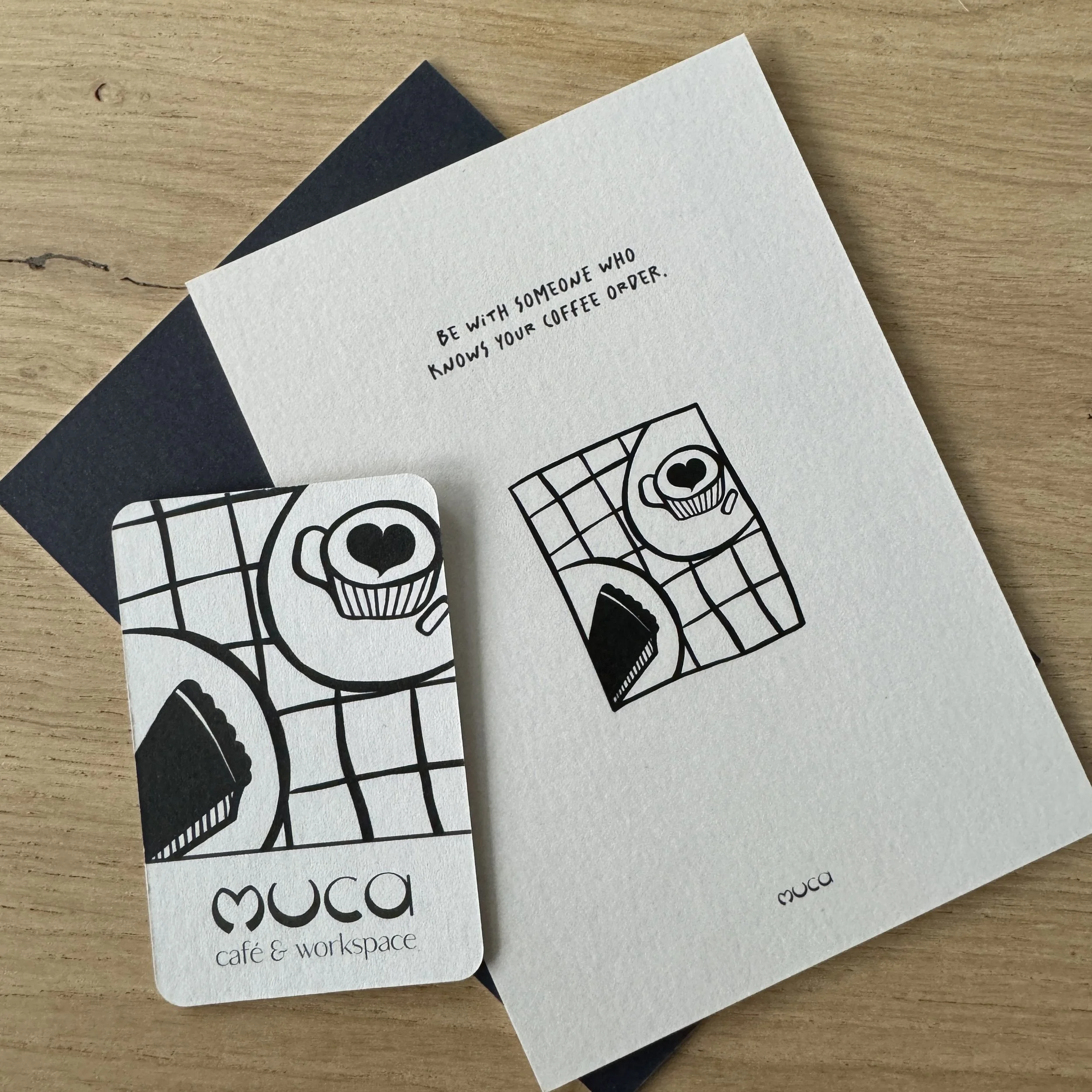 Schwarz-weiß Illustration eines Cupcakes mit Herzform als Gesicht auf einer Gitterunterlage.