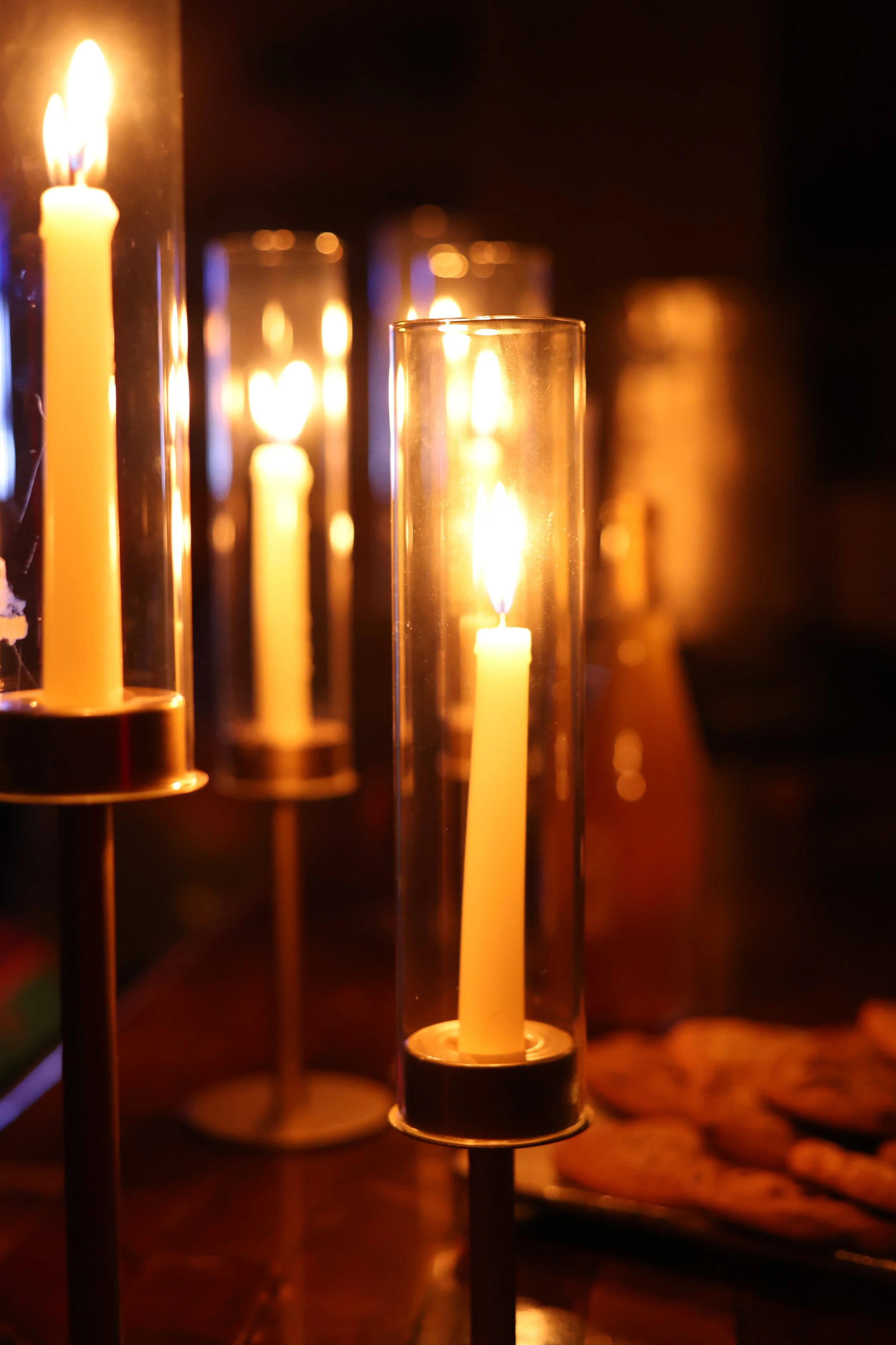Several tall candles inside glass tubes with lit flames, creating a warm, glowing ambiance.